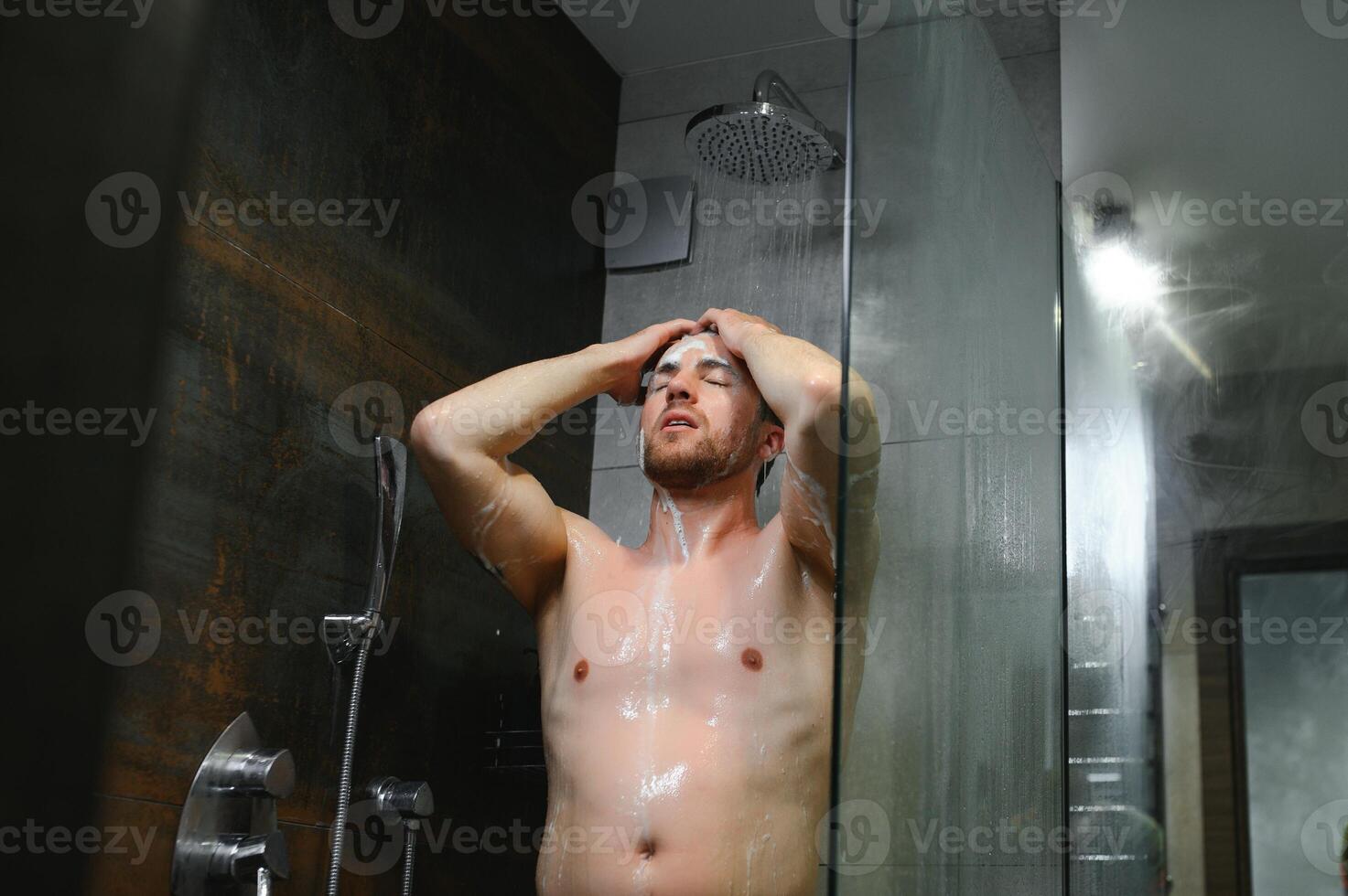 The man is washing his hair, he use shampoo. photo