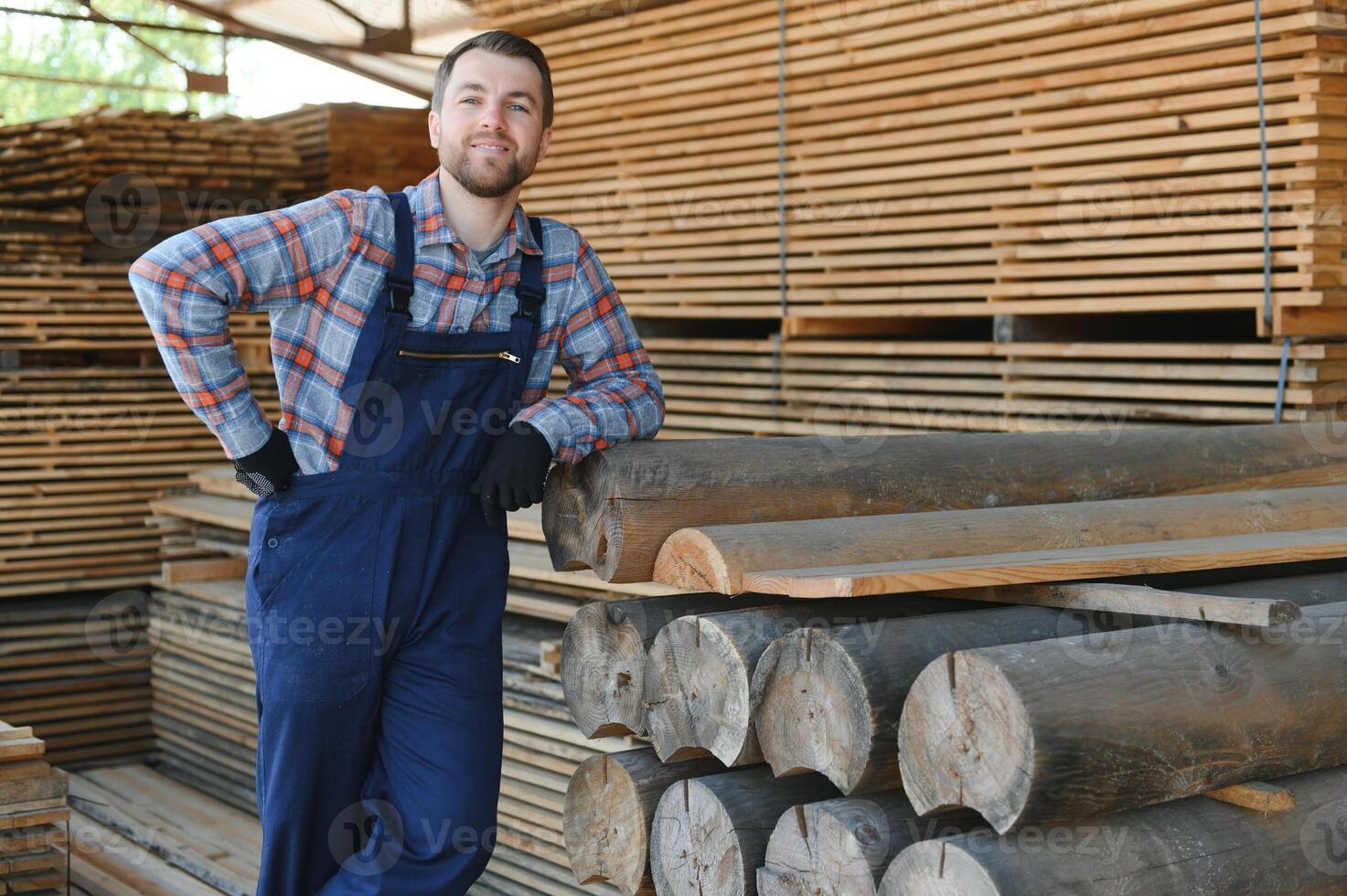 Carpenter in uniform check boards on sawmill photo