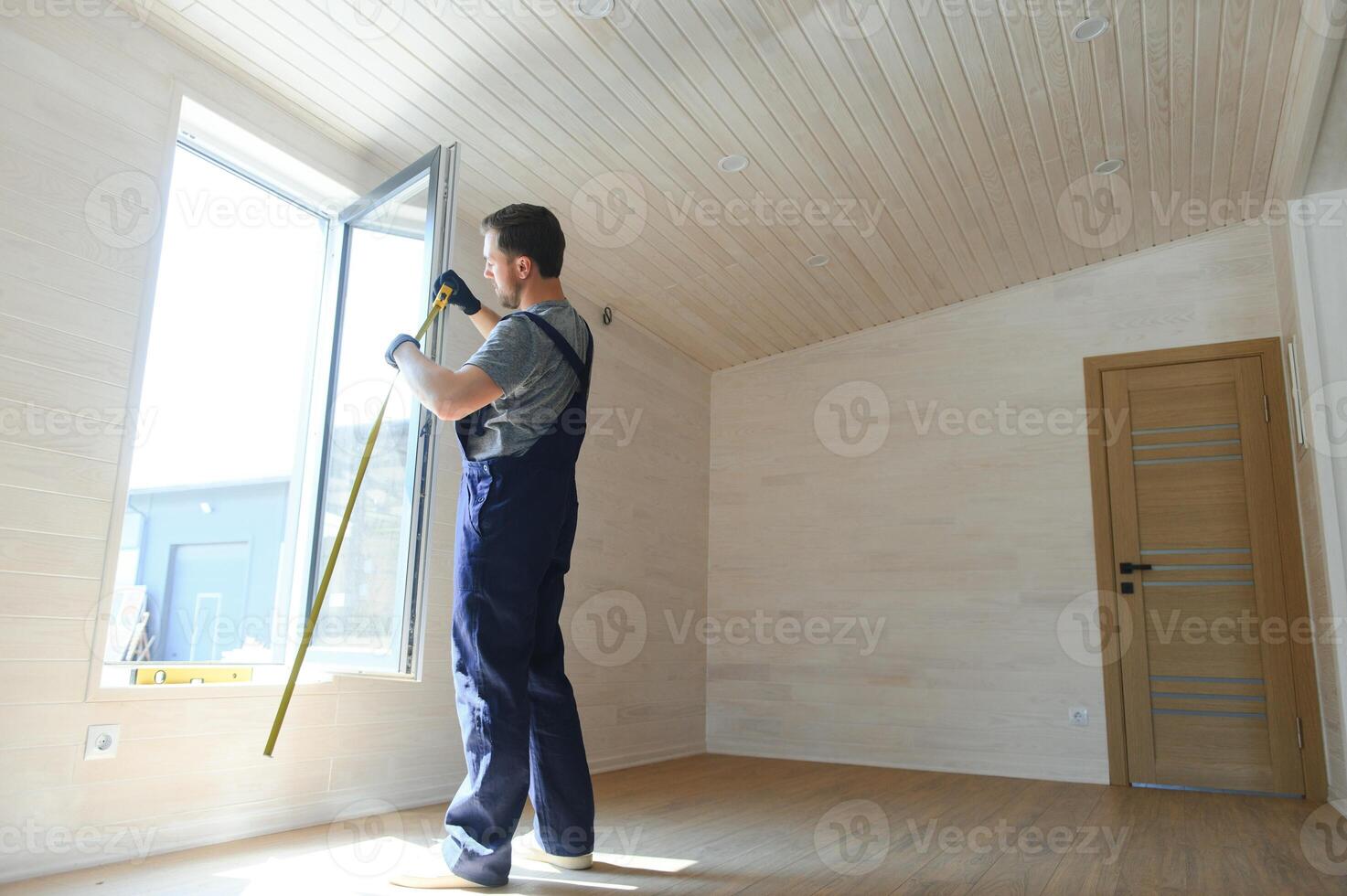 A worker installs windows in a new modular home. The concept of a new home. photo