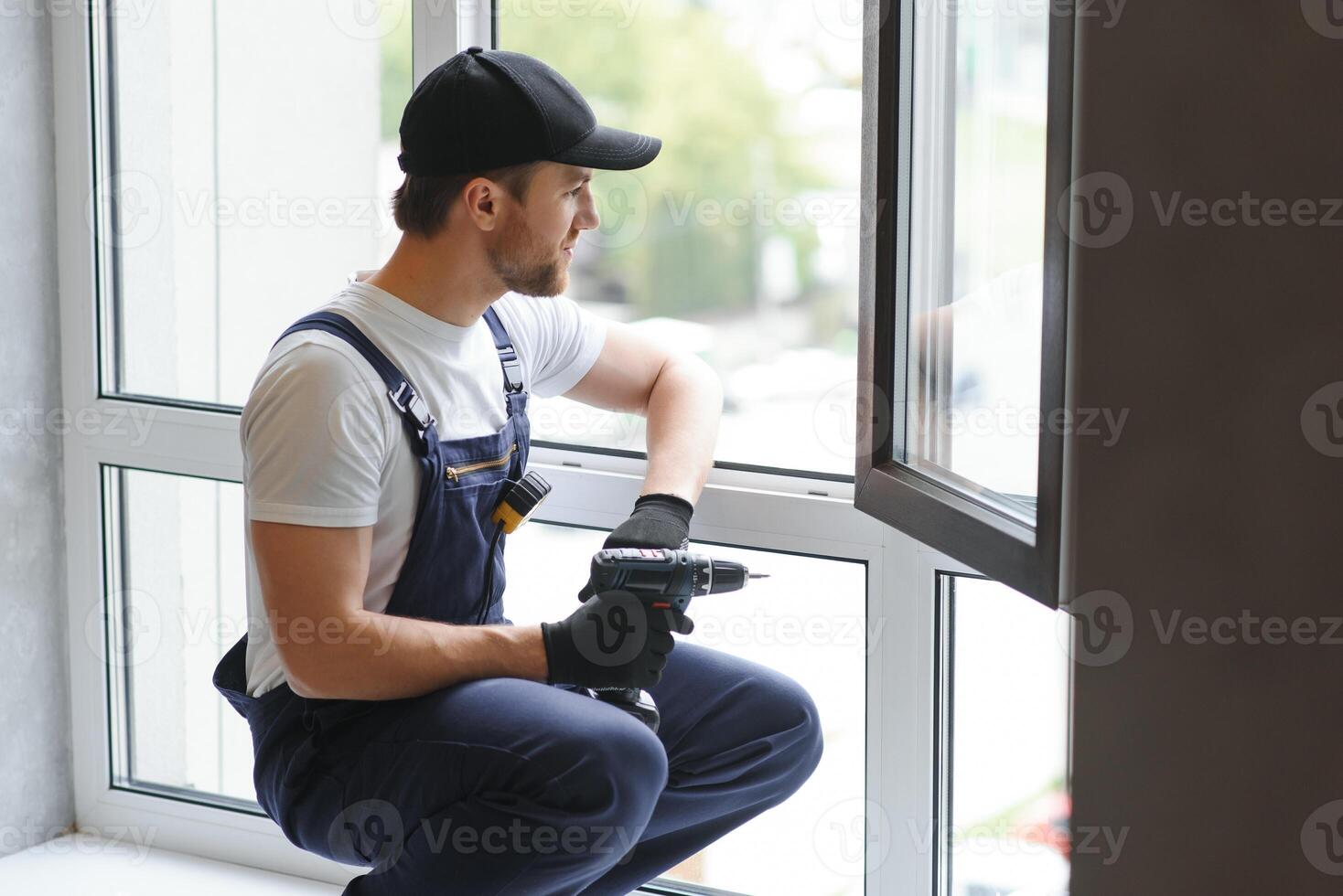 Construction worker installing window in house photo