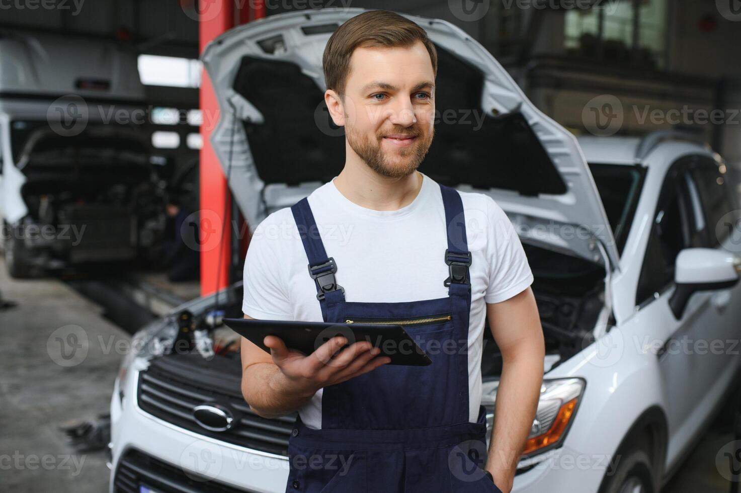 Automobile computer diagnosis. Car mechanic repairer looks for engine failure on diagnostics equipment in vehicle service workshop photo