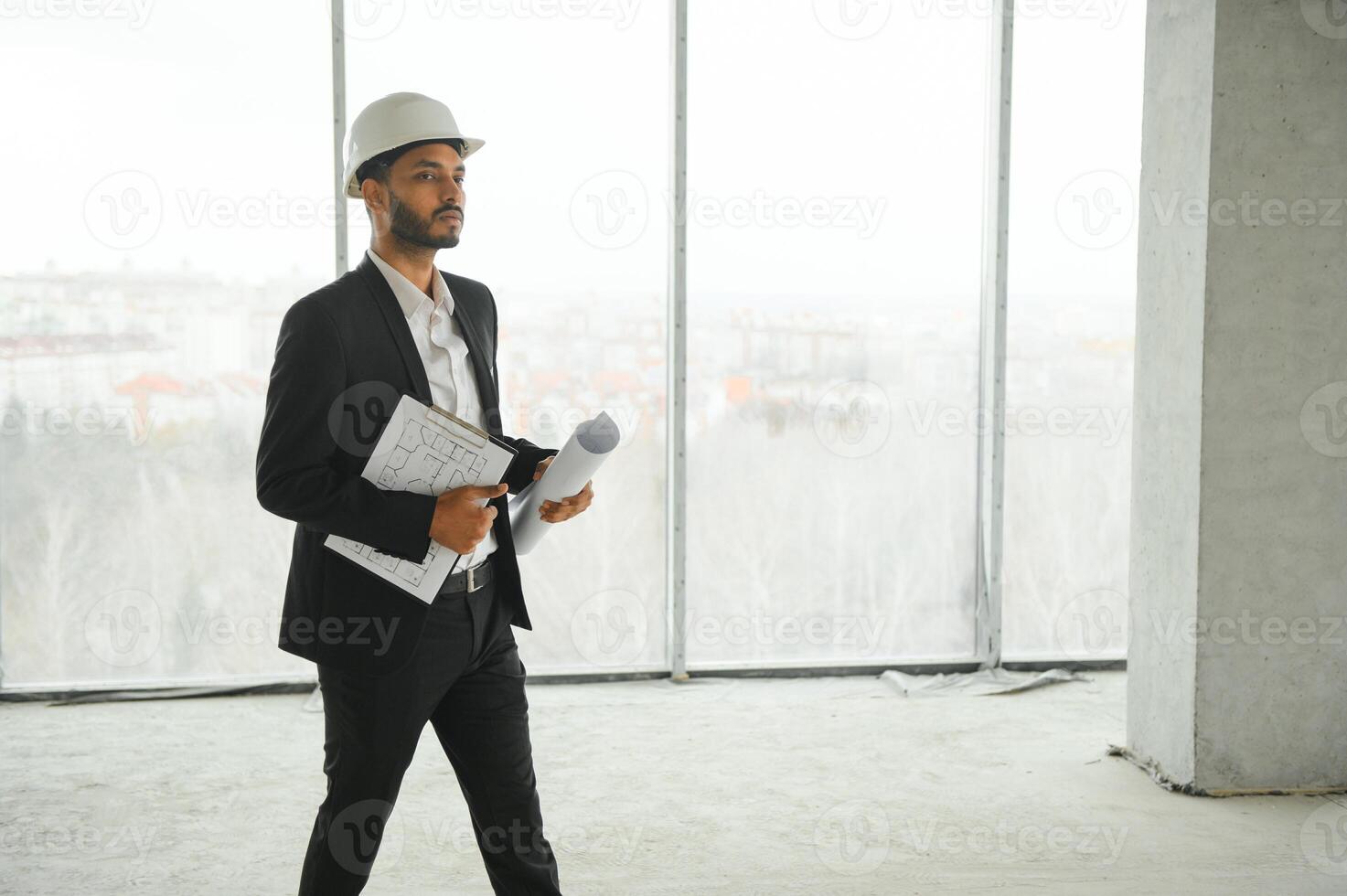 Asian engineer handsome man or architect with white safety helmet in construction site. Standing at modern building construction. Worker asian man working project building photo
