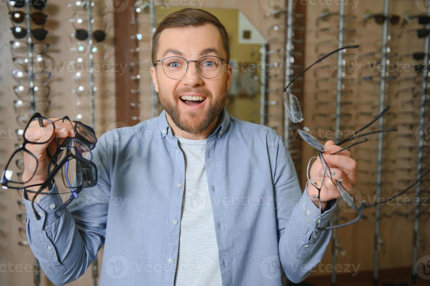 Man is choosing glasses in optics store. photo