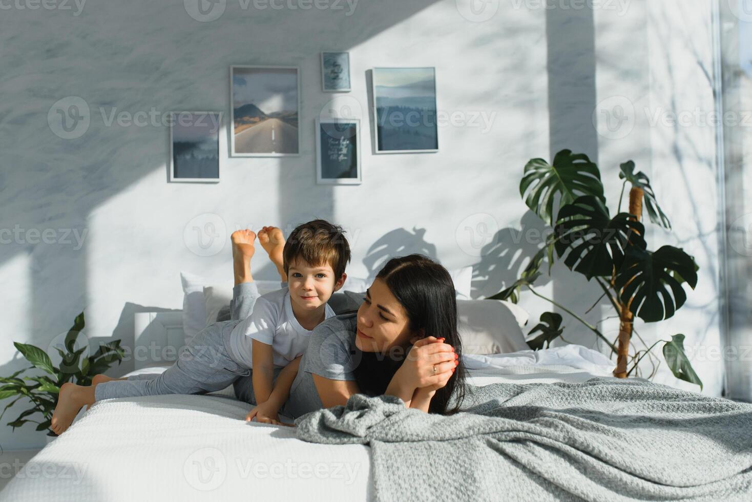 Portrait of a happy mother and her children son lying on a bed photo