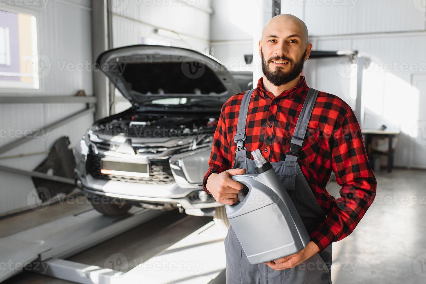 the car mechanic replaces the oil in the car. Car mechanic replacing and pouring fresh oil into engine car. photo