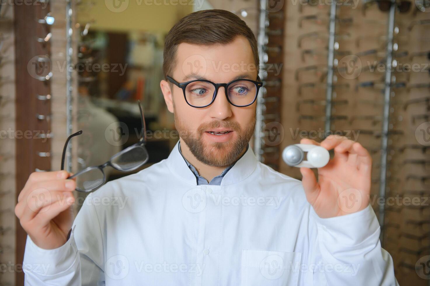 Eye doctor choosing between eyeglasses and lenses standing in the cabinet photo