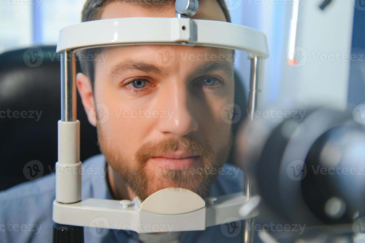 Adult man eyesight test with binocular slit-lamp. Checking retina of a male eye close-up. Ophthalmology Clinic photo