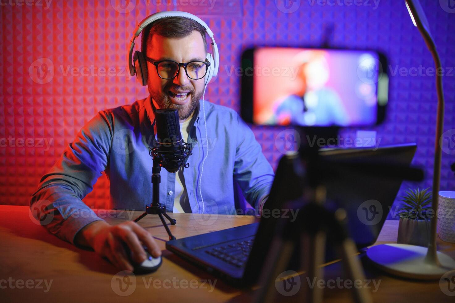 A video blogger records content in his studio. The host of the video blog is a young man who is very enthusiastic about telling his subscribers a story. photo