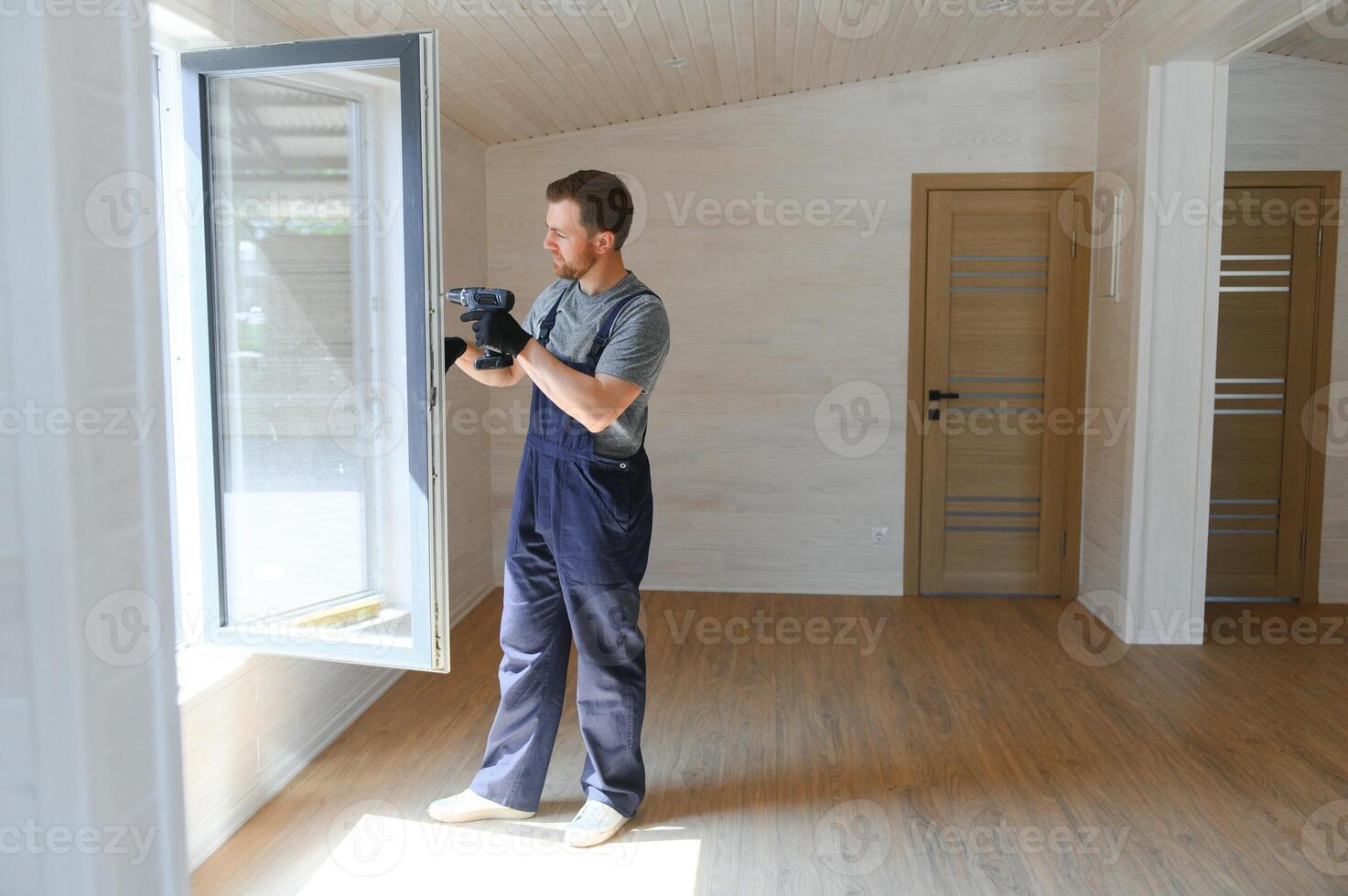 A worker installs windows in a new modular home. The concept of a new home. photo