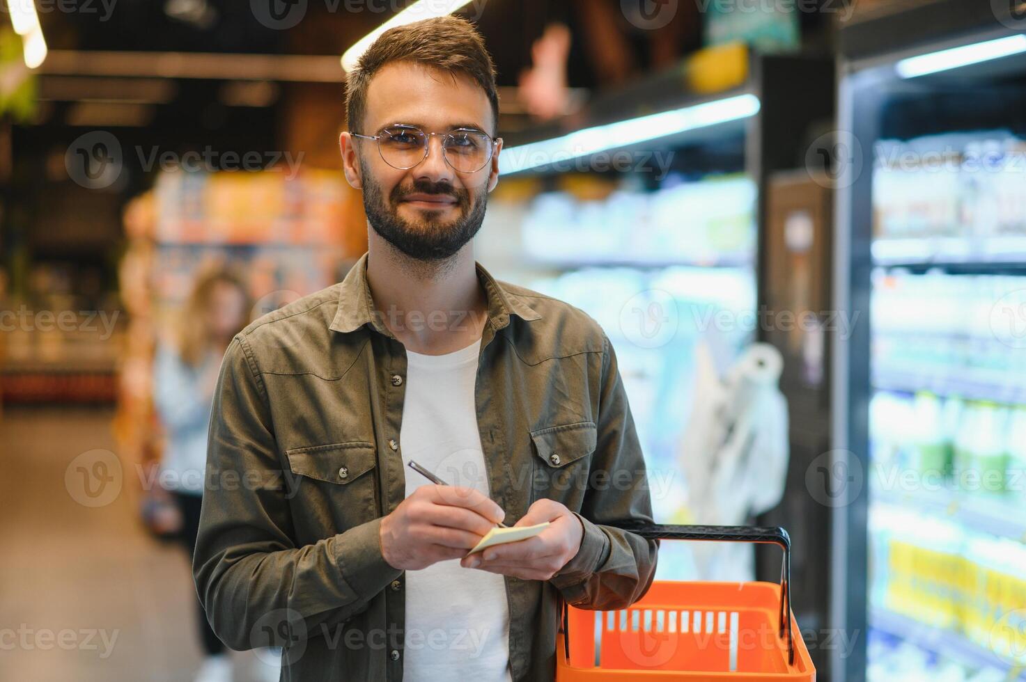 sonriente masculino cliente haciendo tienda de comestibles compras foto