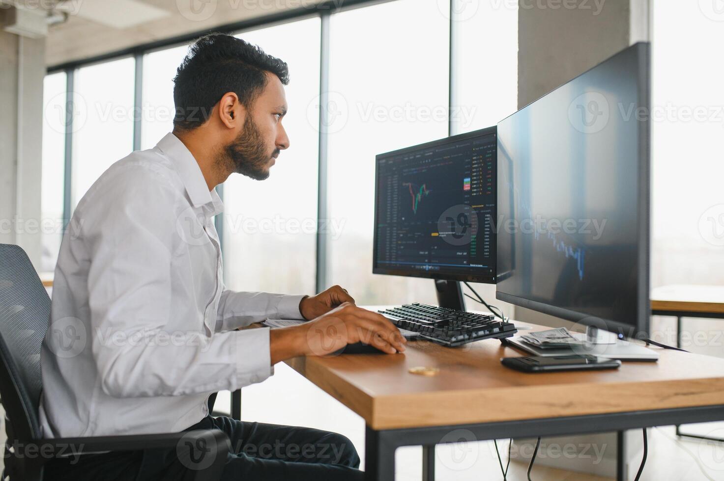 Portrait of a positive successful Indian or Arabian trader, stock market broker, Crypto charts on laptop screen photo