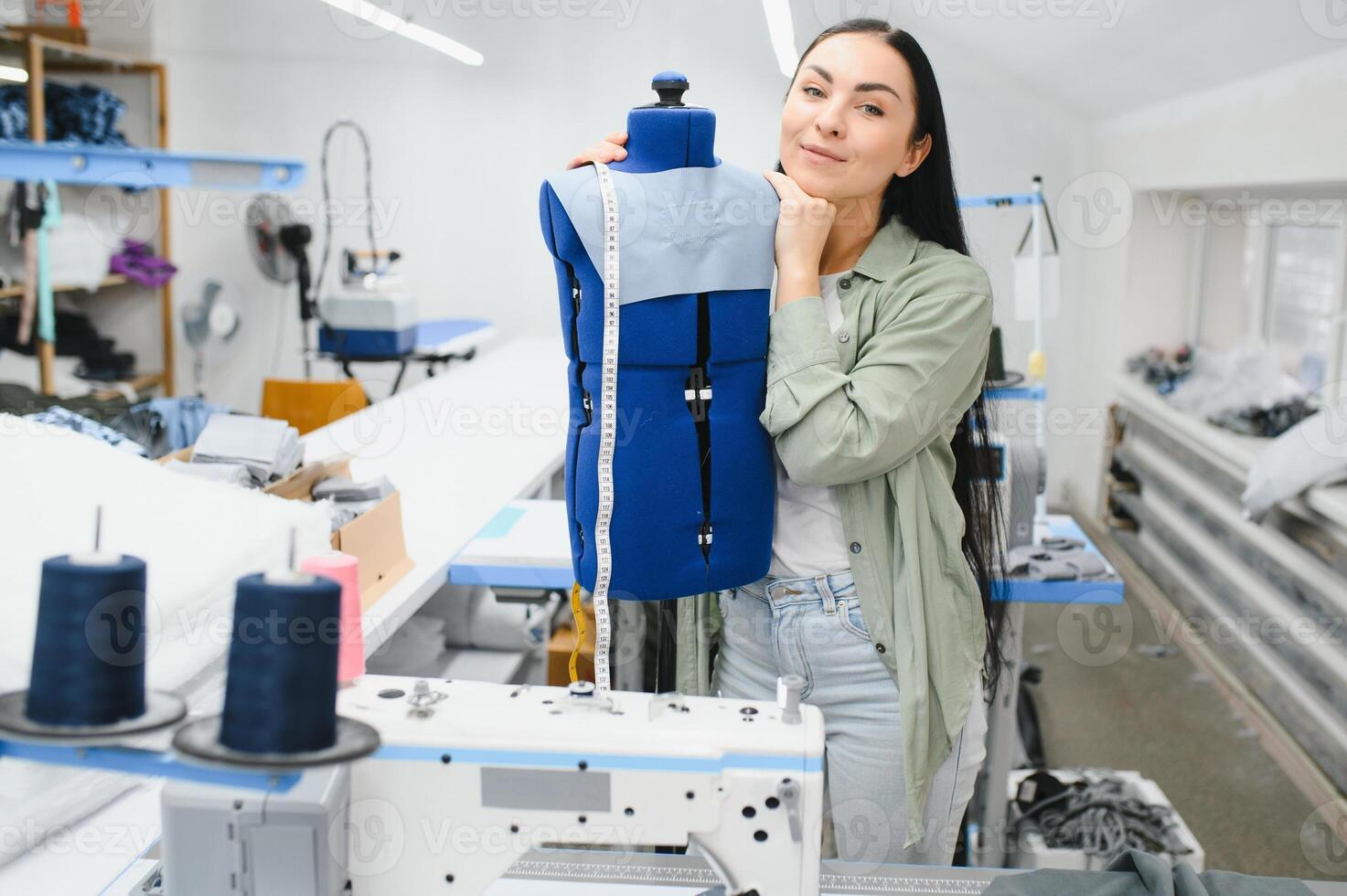 joven mujer trabajando como costurera en ropa fábrica. foto