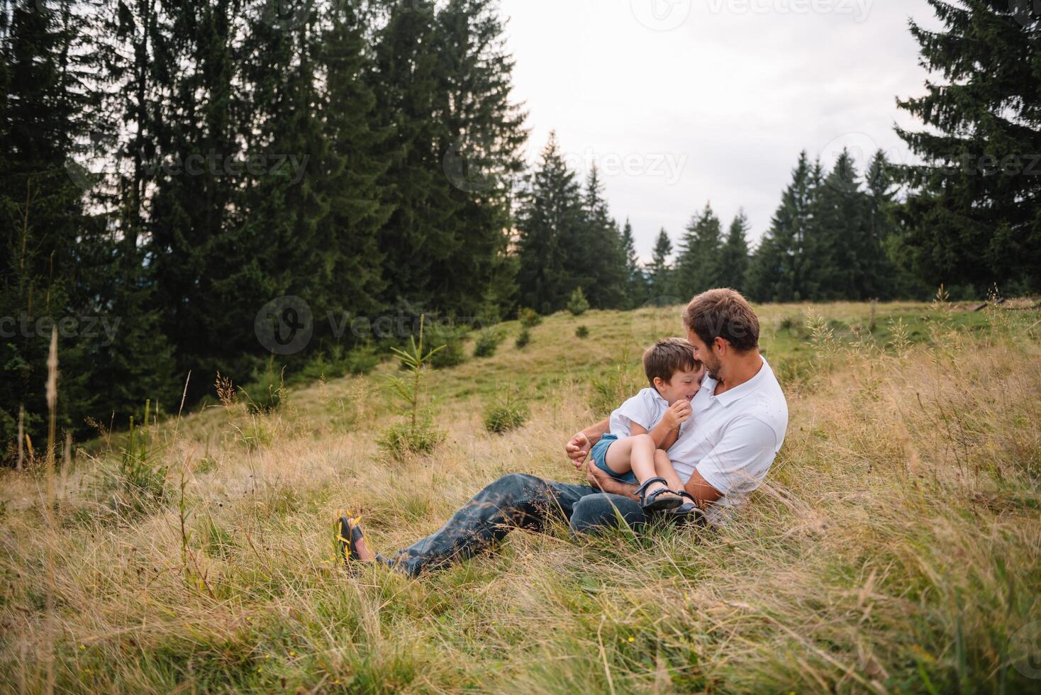 Father and child hiking in scenic mountains. Dad and son enjoying the view from the mountain top in Carpathian mountains photo