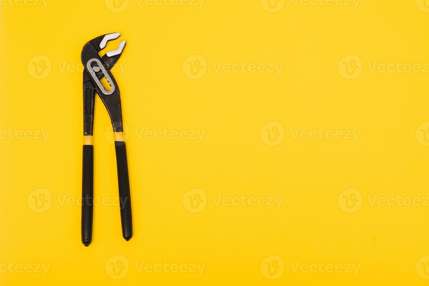 Yellow locking pliers isolated on yellow background with clipping path photo