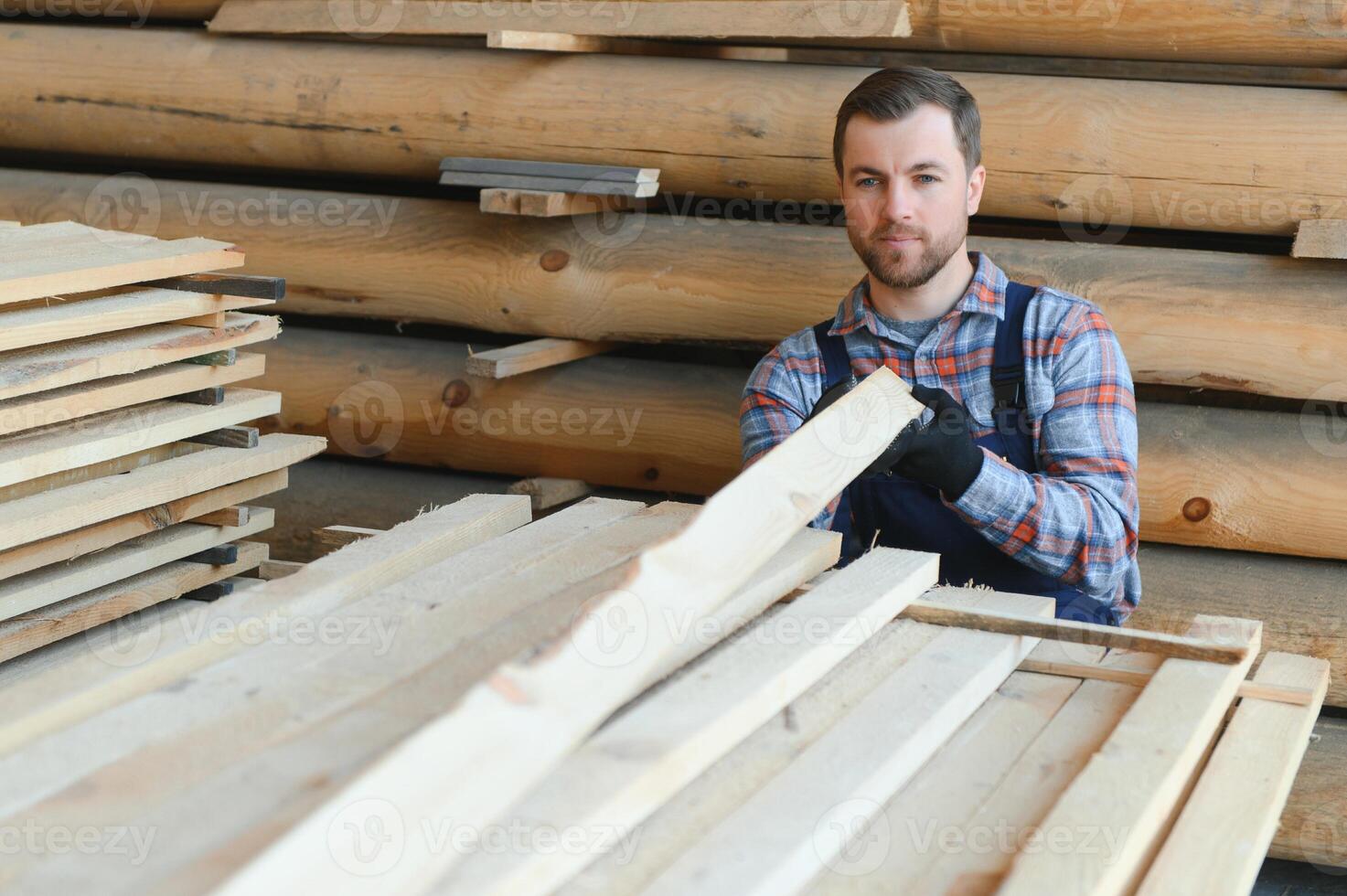 Builder holds wooden planks. Concept - sale of lumber. Builder is considering wood planks. Concept - wood processing business. wood timber stack of wooden planks. photo