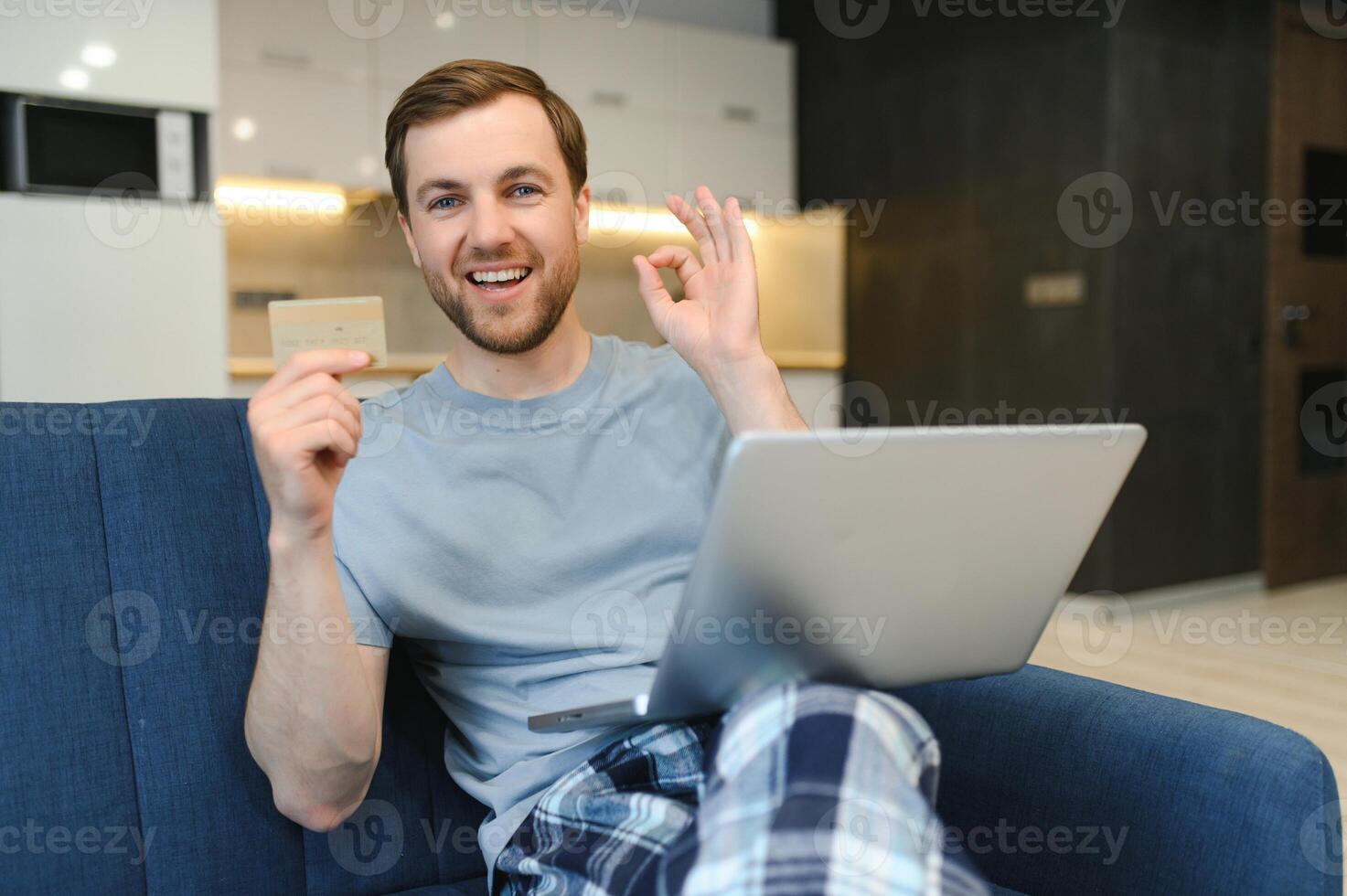 Smiling man during online shopping at home photo