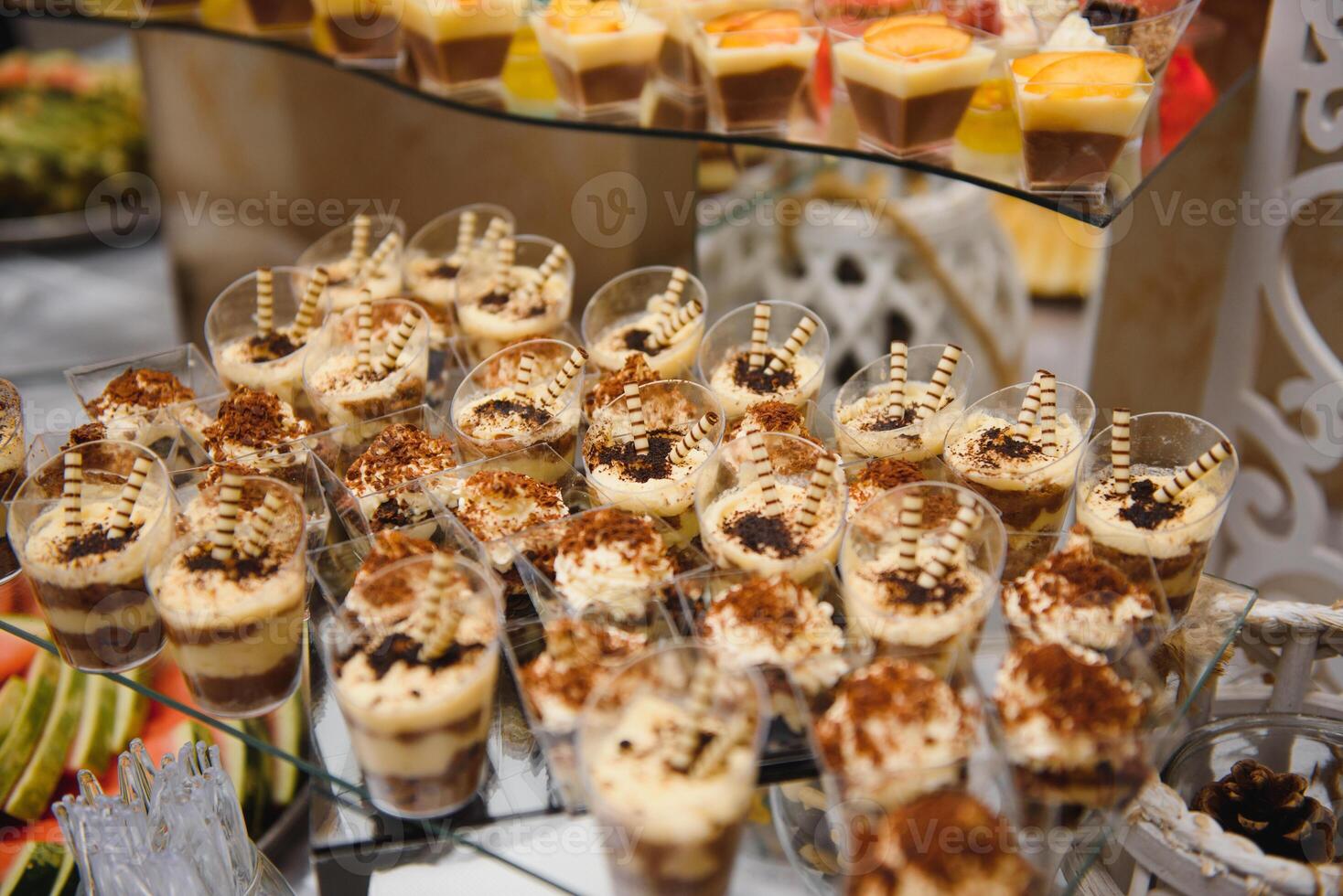 desserts with fruits, mousse, biscuits. Different types of sweet pastries, small colorful sweet cakes, macaron, and other desserts in the sweet buffet. candy bar for birthday photo