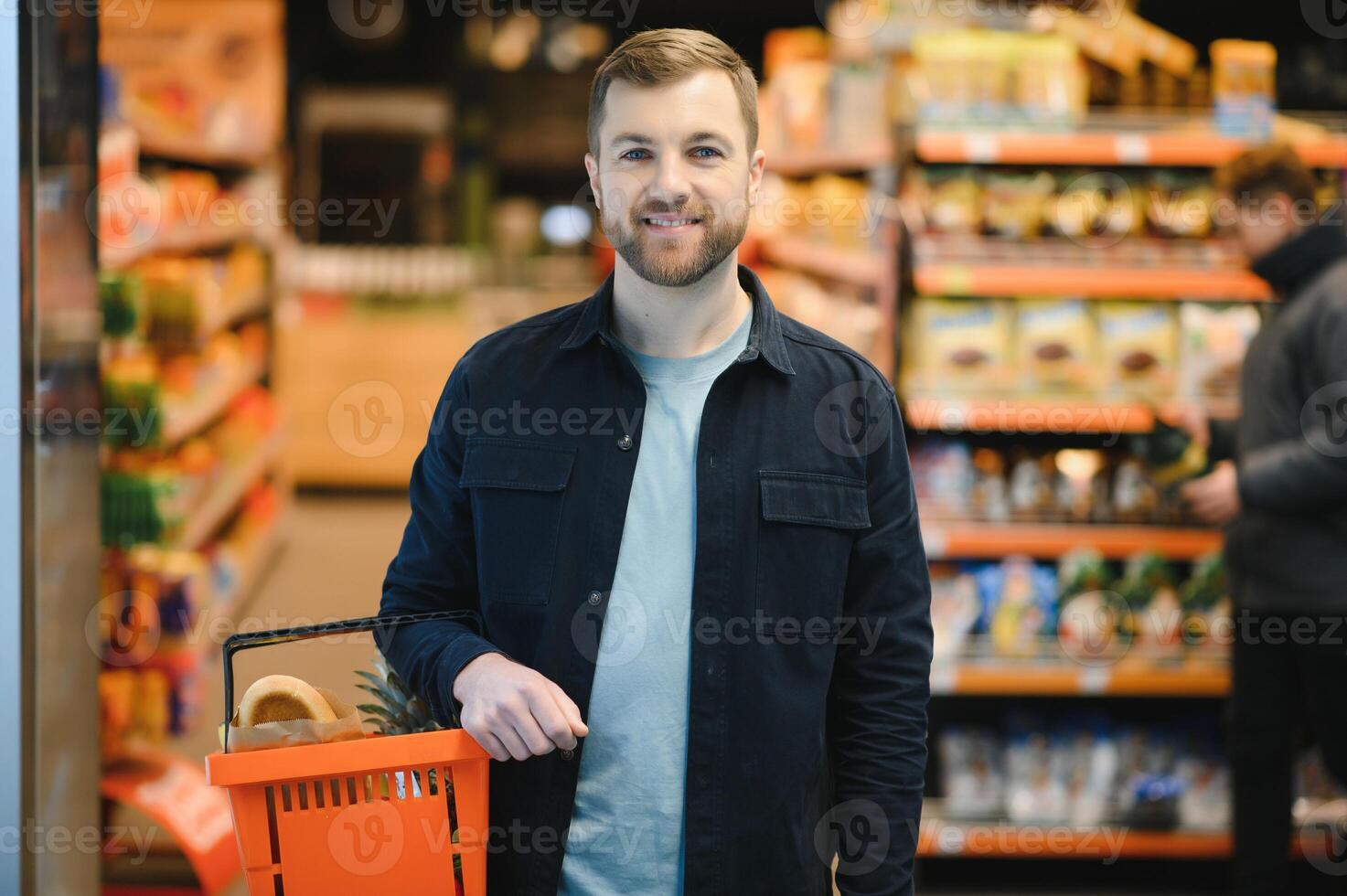 hermoso joven hombre elegir comida en el supermercado foto