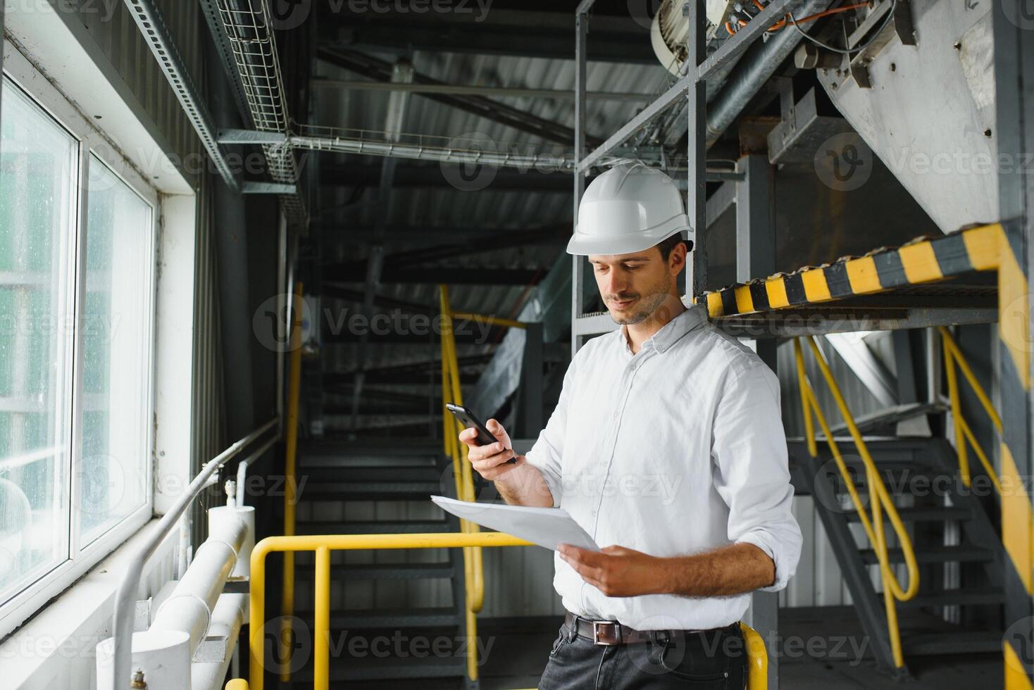 happy male industrial technician inside a factory photo