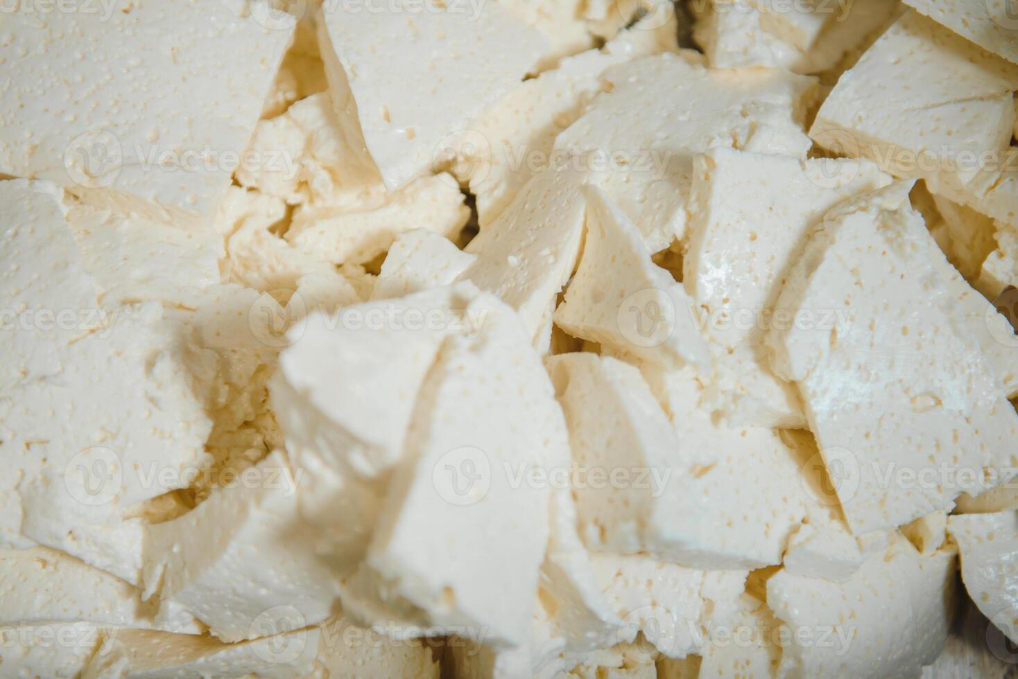 Assorted flavours of cheese wheels maturing on rows of wooden shelves in a cheese factory photo