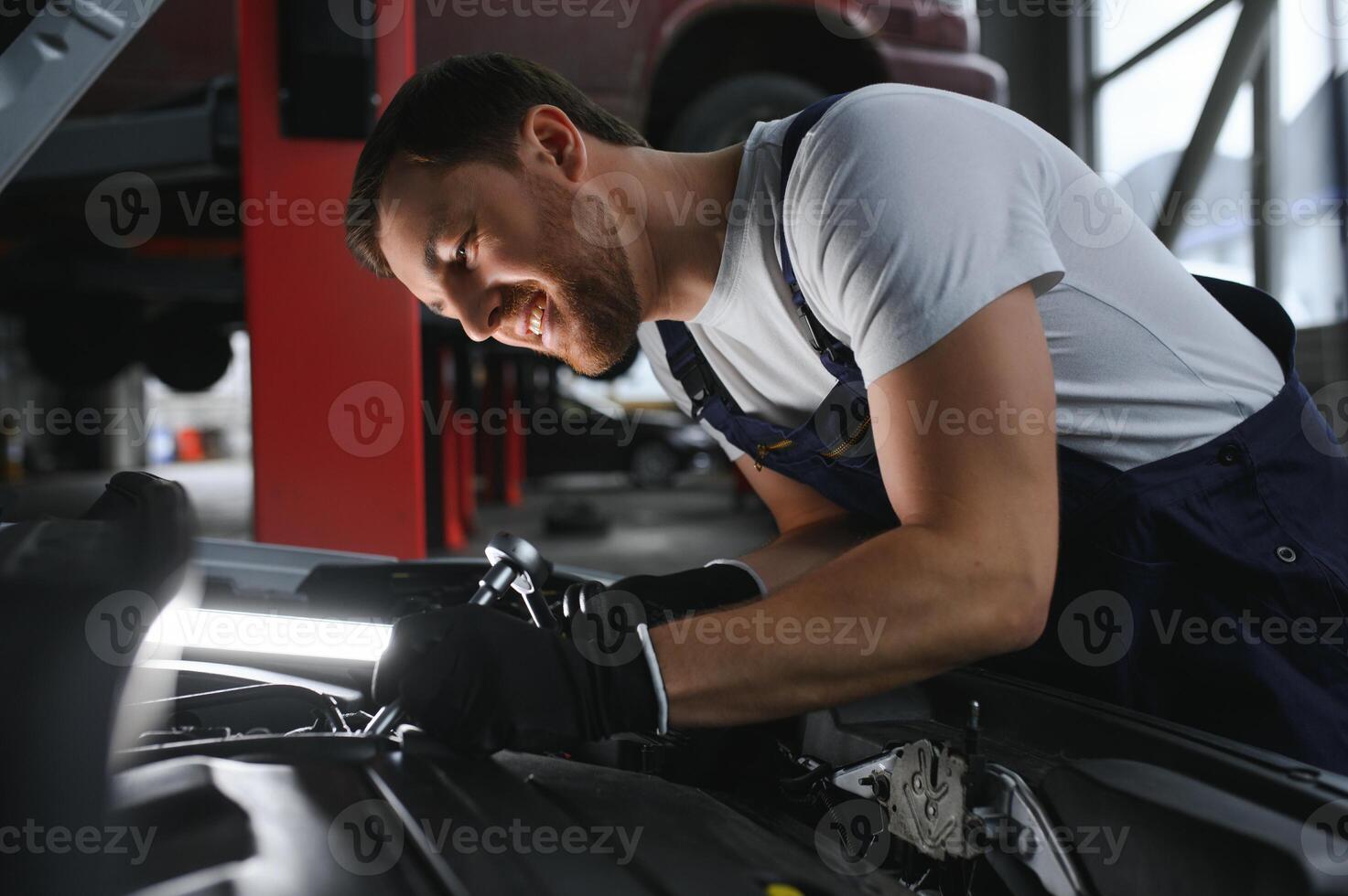 Portrait of a smiling fixing a car engine in his garage photo