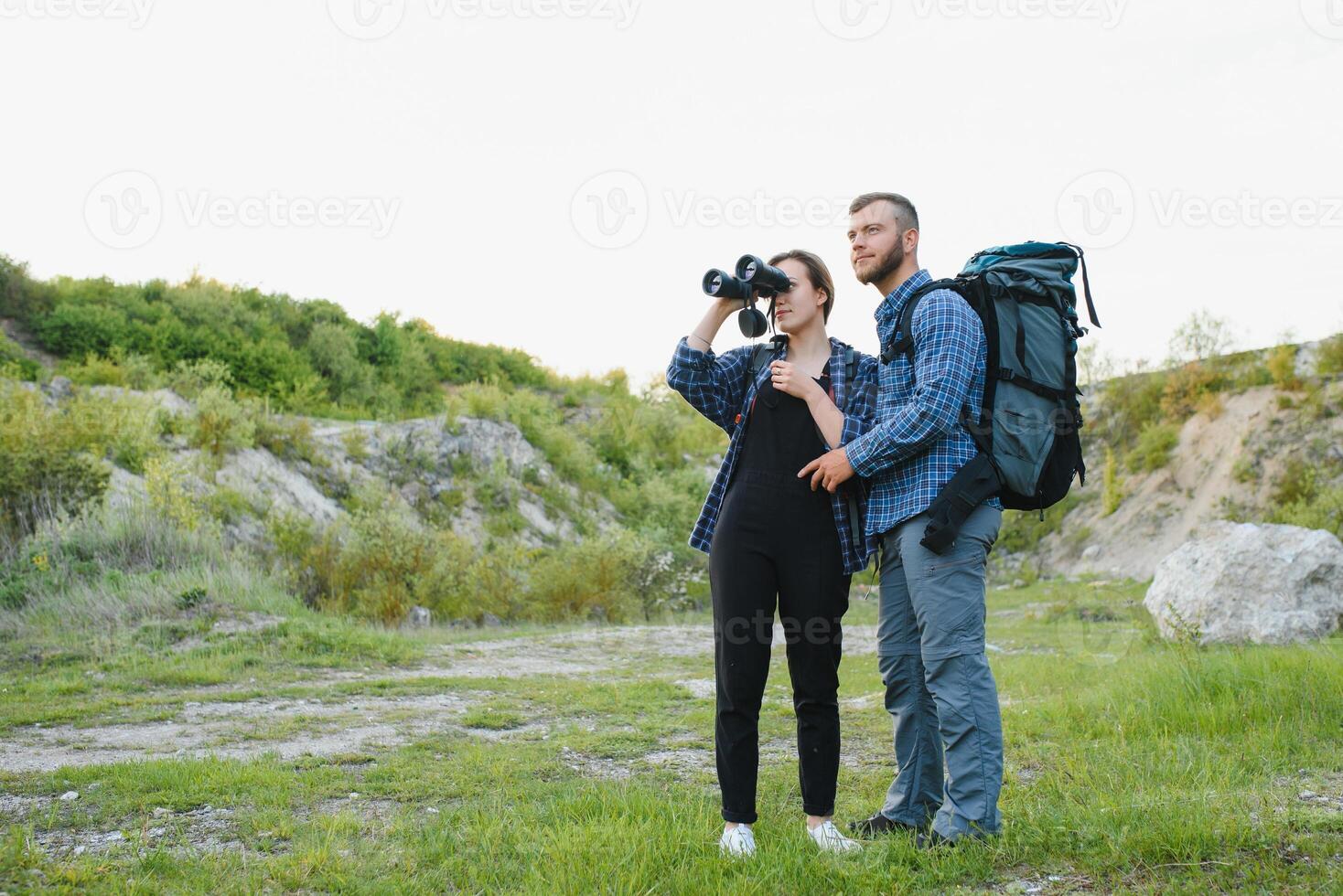 un Pareja de turistas en hora de viaje acero y admirar el hermosa montaña escenario. el chico abrazos el muchacha. el concepto de amar, sensibilidad y recreación foto