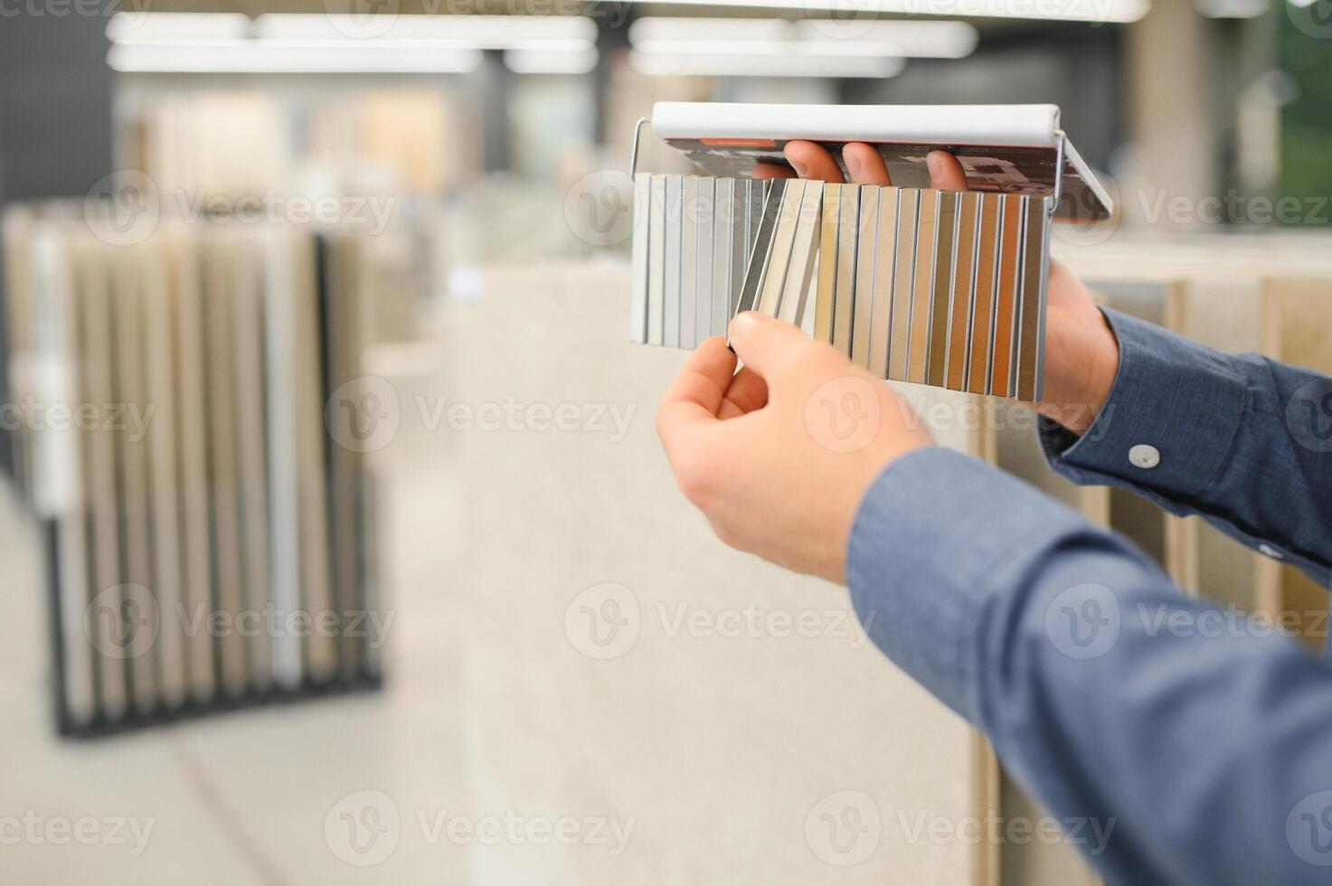 man choosing ceramic tiles and utensils for his home bathroom photo