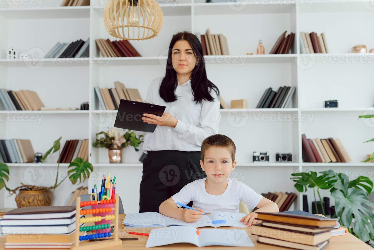 retrato de inteligente tutor con lápiz de corrección errores en alumnos cuaderno foto