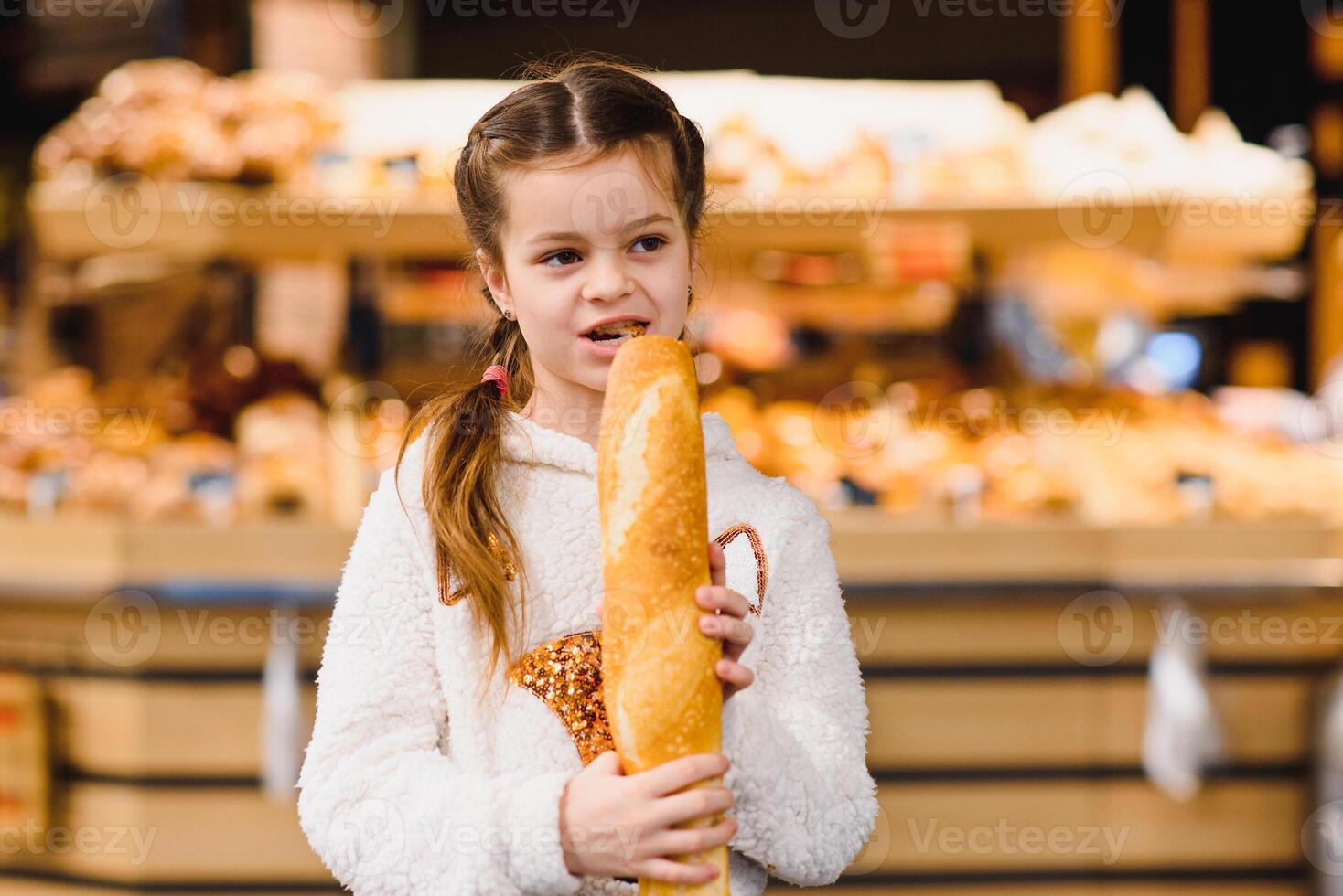 little girl with a baguette in the store photo