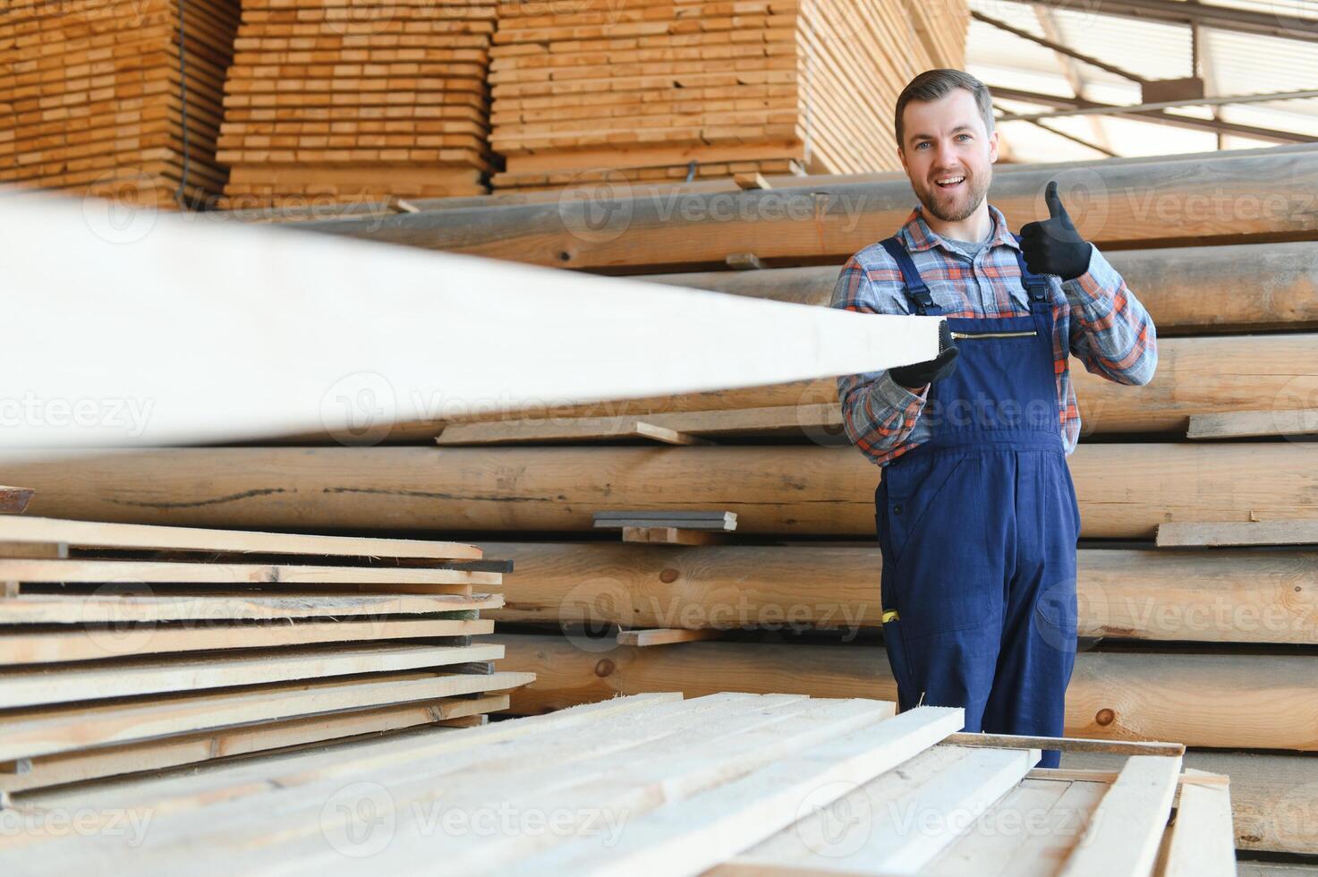 Carpenter in uniform check boards on sawmill photo