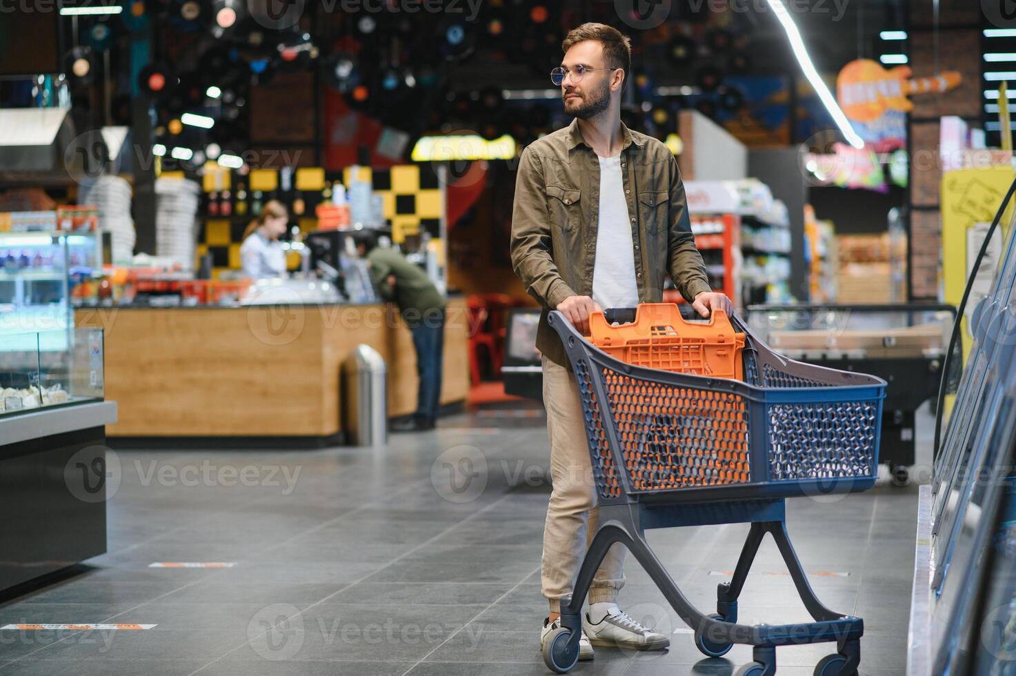 Handsome young man choosing food in the supermarket. photo