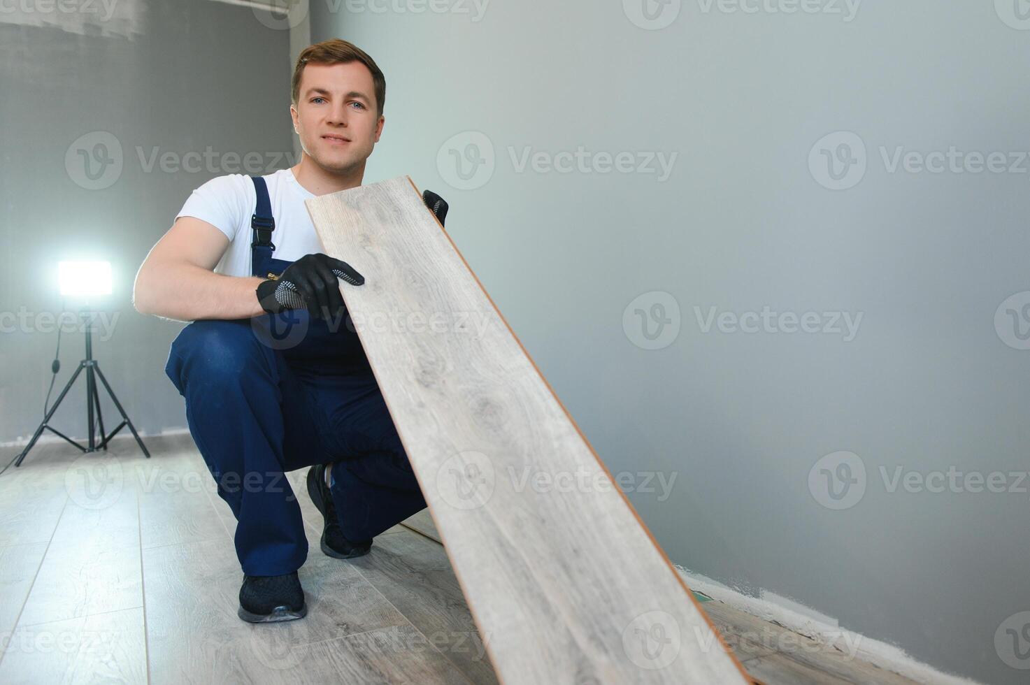 bricolaje, reparar, edificio y hogar concepto - hombre acostado parquet piso tablero o laminado piso foto