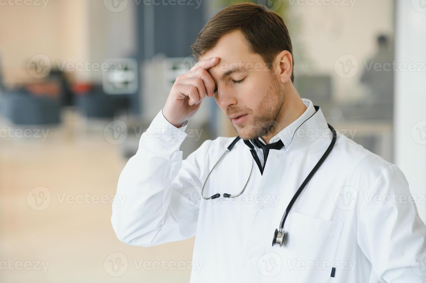 Handsome doctor man wearing medical uniform over isolated background tired rubbing nose and eyes feeling fatigue and headache. Stress and frustration concept photo