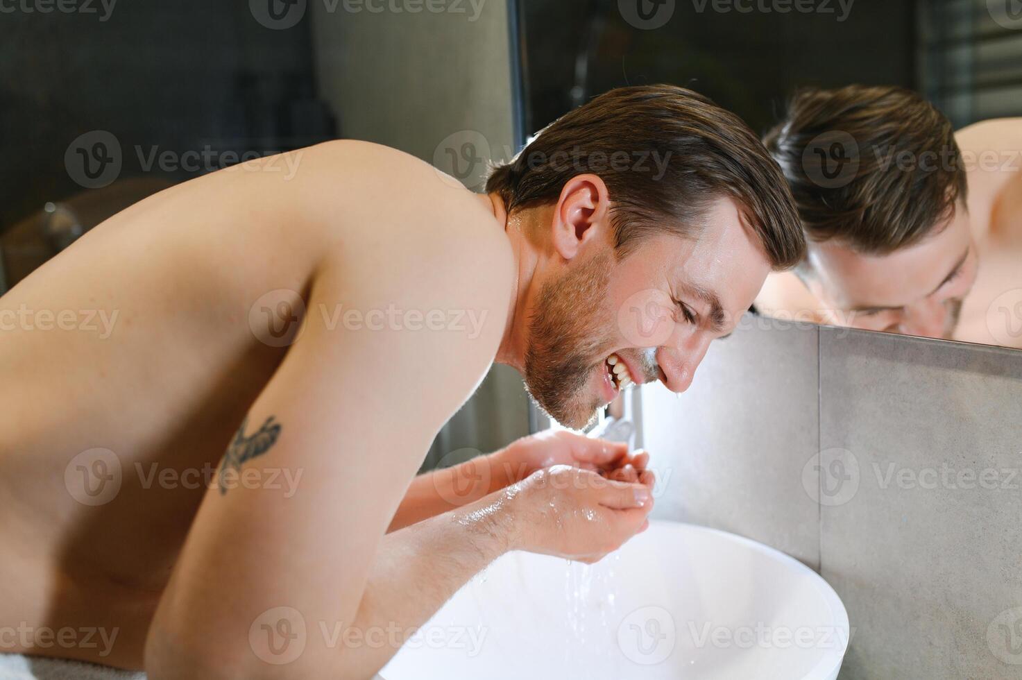 A man washes his face after shaving photo