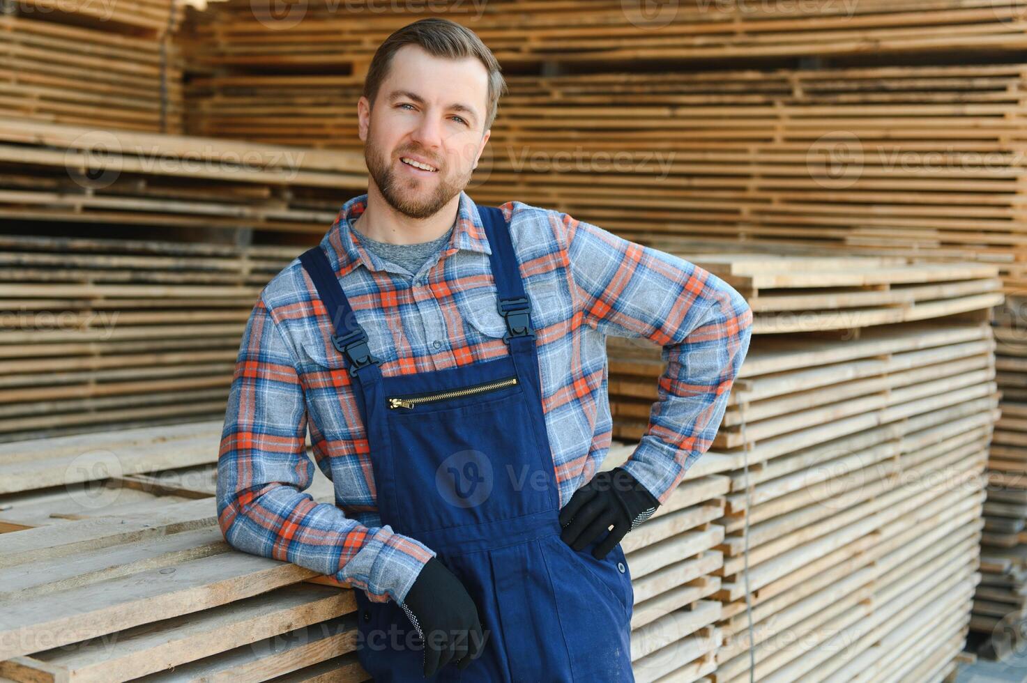 Male Worker folds boards. Sawmill. Wood harvesting process photo