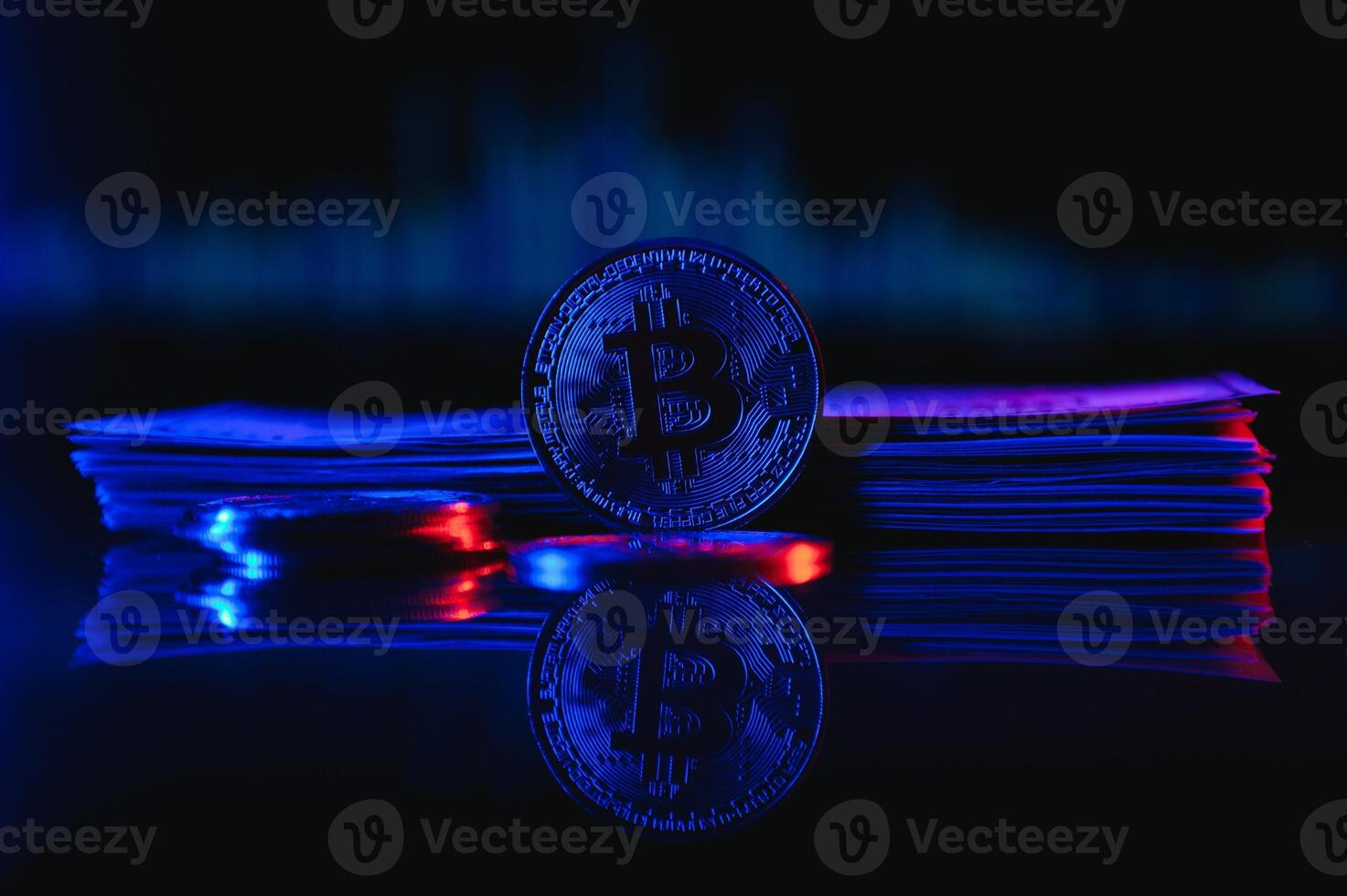 Golden bitcoin are stacked on a bright background of business graphs close-up. Bitcoin cryptocurrency. Folded in a tube 100 dollar bills photo