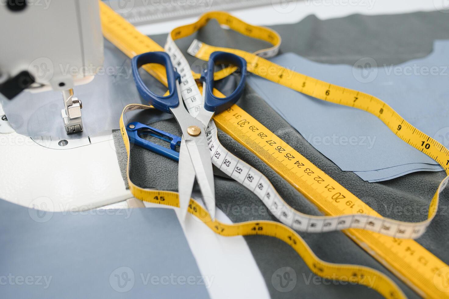 Composition of sewing thread, scissors and tape measure on a white table. Concept of a clothing designer photo