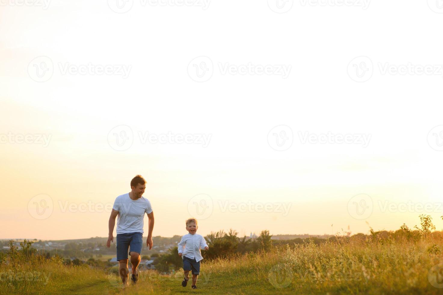 del padre día. contento familia padre y niñito hijo jugando y riendo en naturaleza a puesta de sol foto