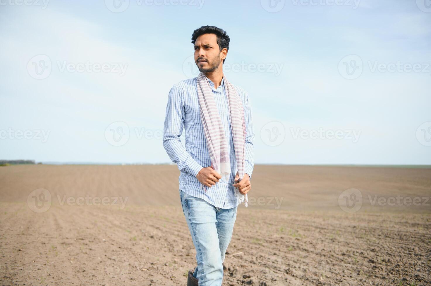 A young Indian farmer inspects his field before sowing. photo