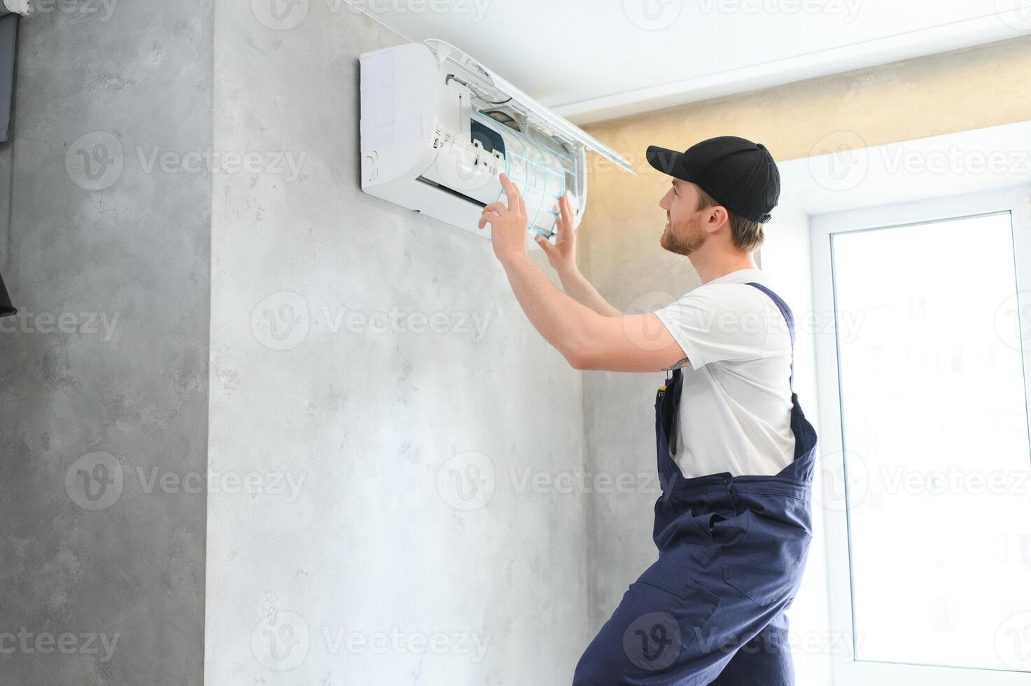 Happy Male Technician Repairing Air Conditioner. photo