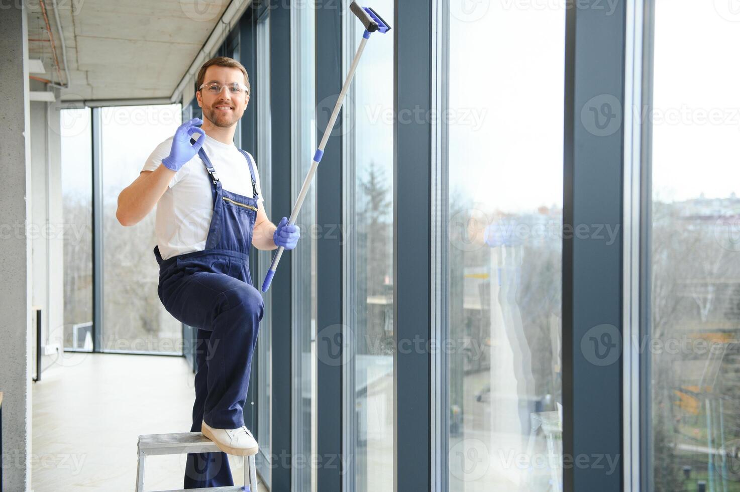 An employee of a professional cleaning service washes the glass of the windows of the building. Showcase cleaning for shops and businesses. photo