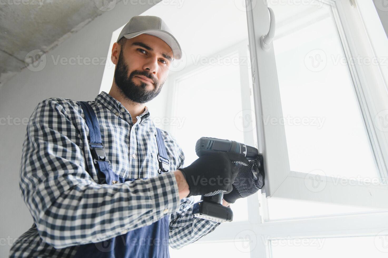 Construction worker installing window in house photo