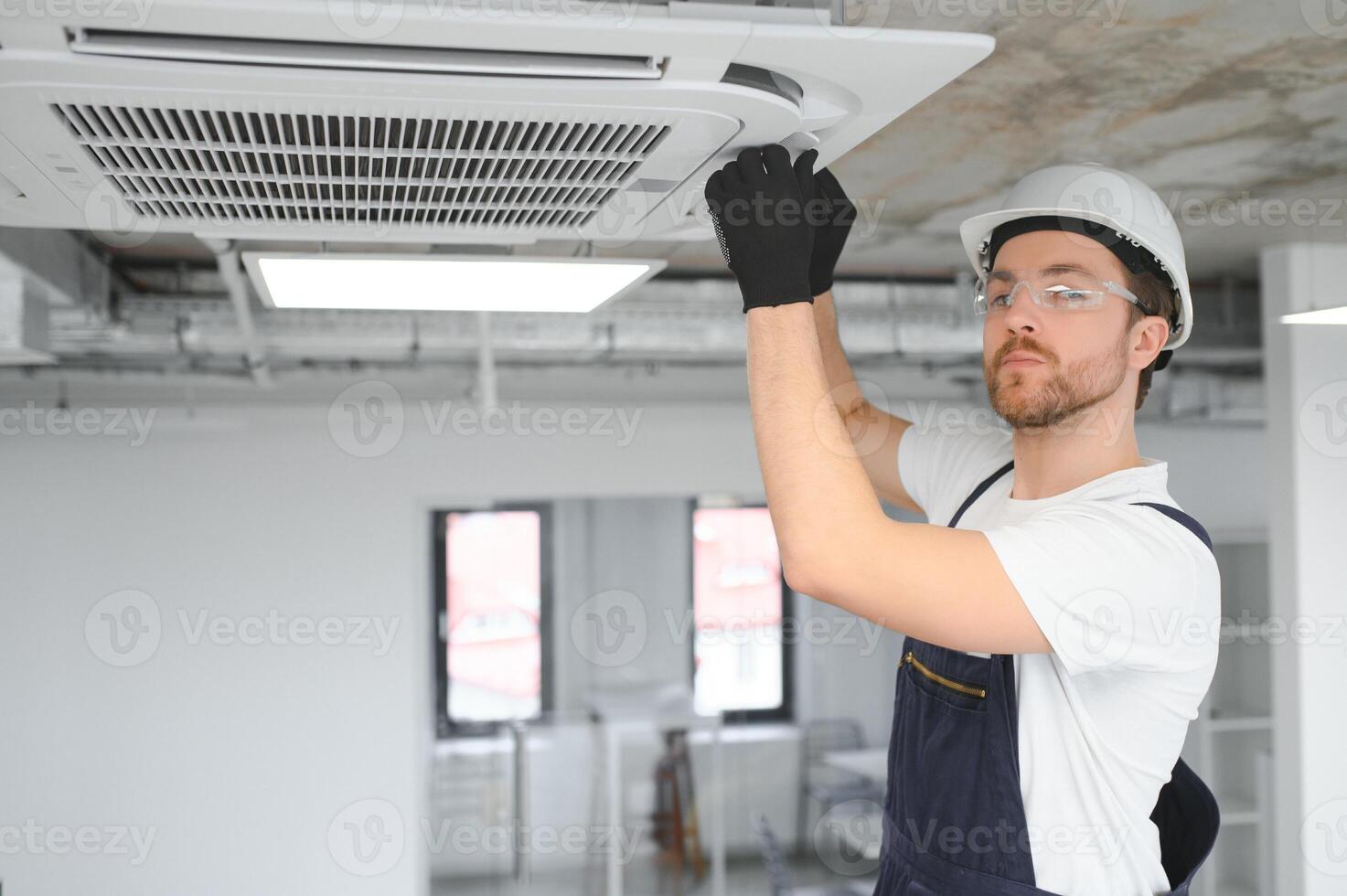 Electrician repairing air conditioner indoors photo