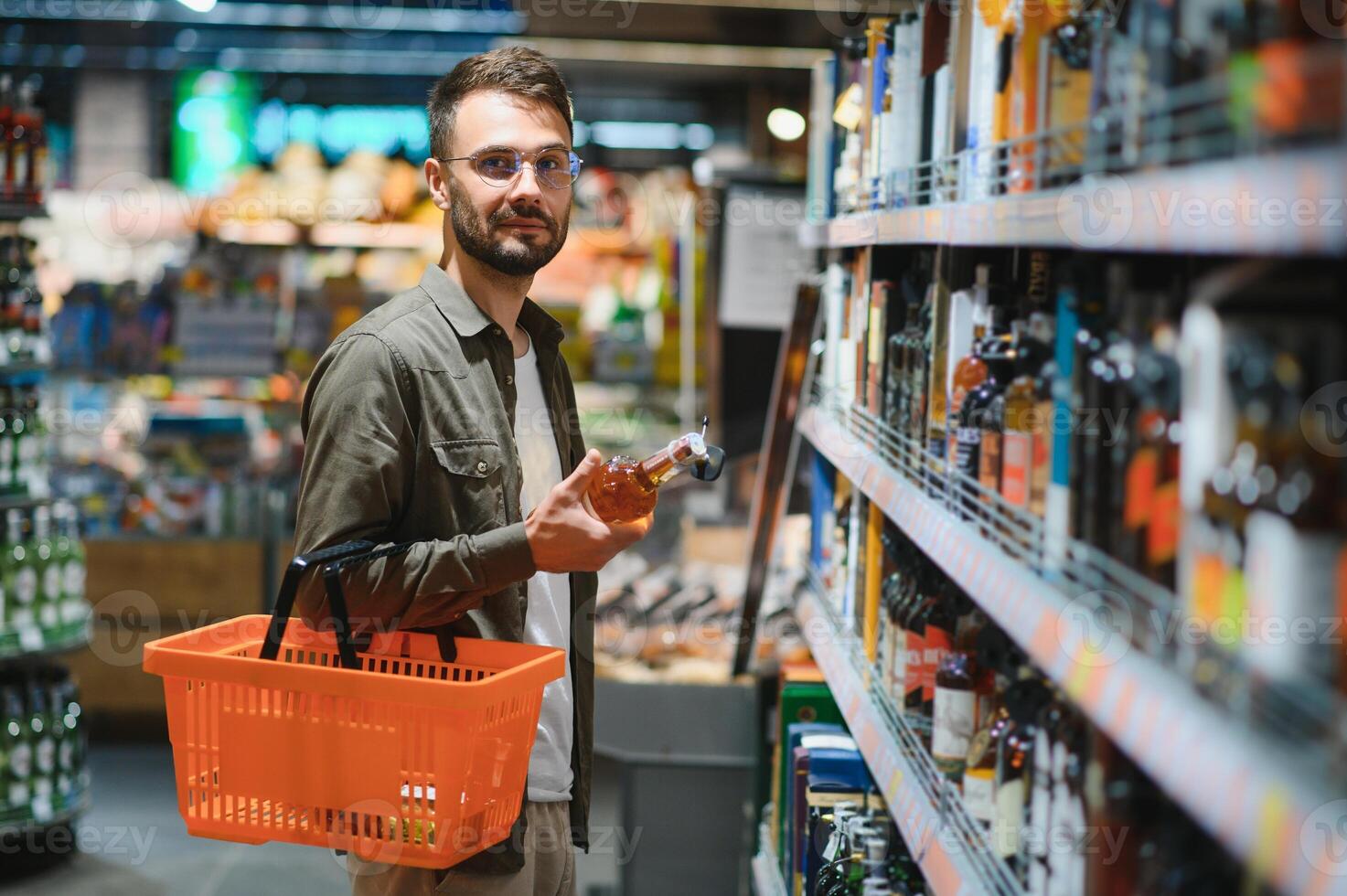 A man takes alcoholic drinks from the supermarket shelf. Shopping for alcohol in the store photo