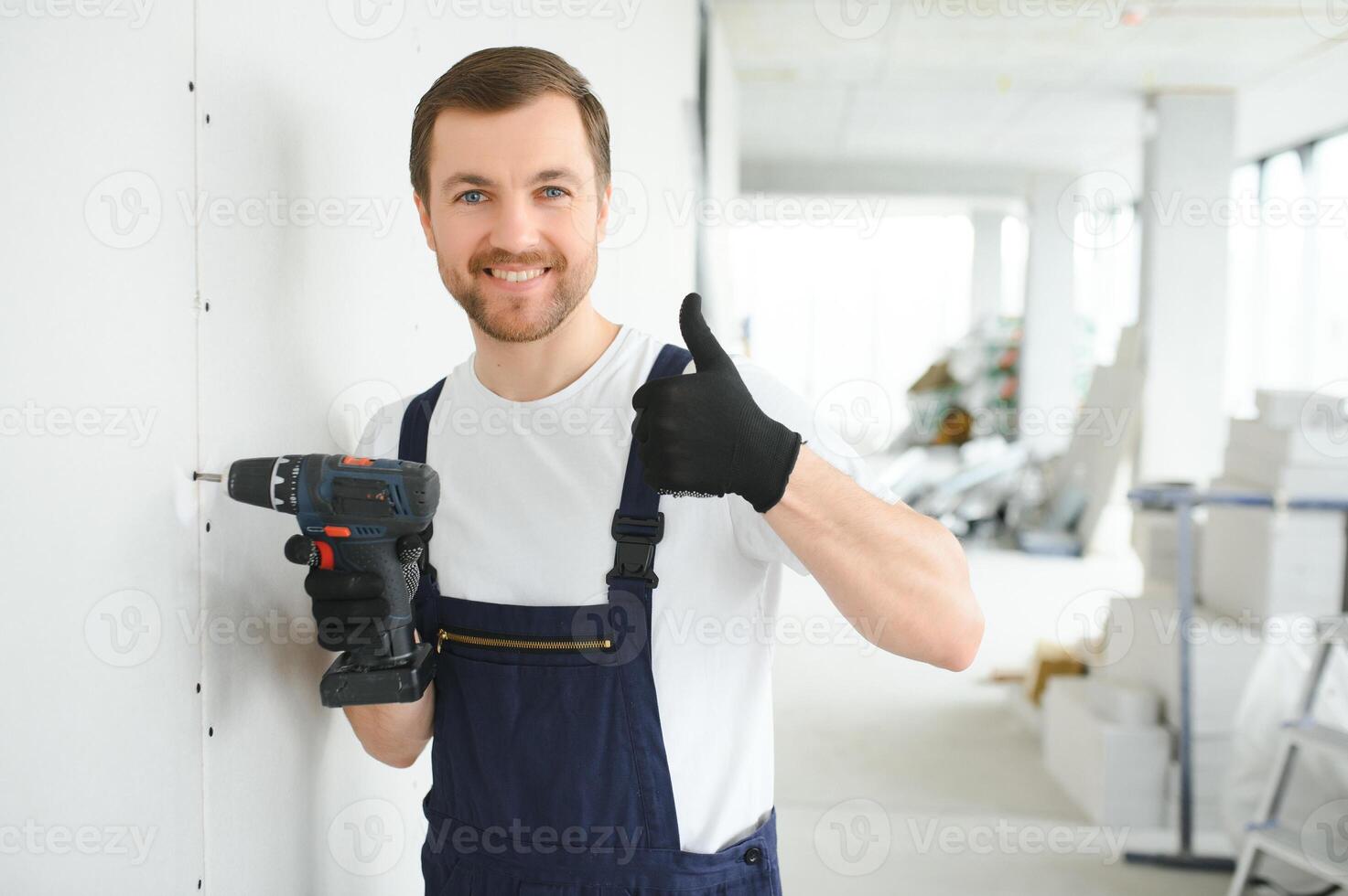 Worker builder installs plasterboard drywall at a construction photo