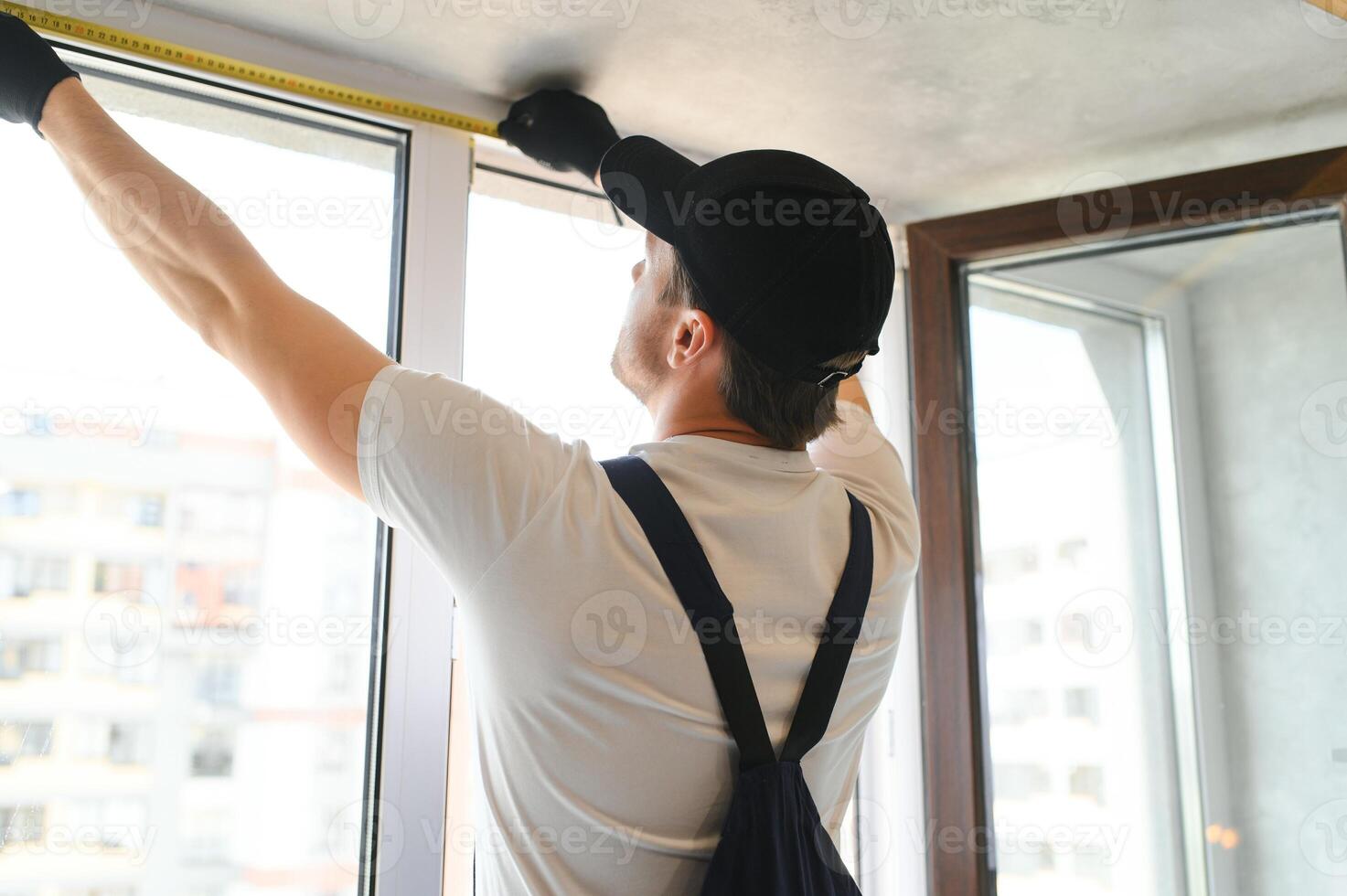 el capataz instala un ventana marco en el habitación foto