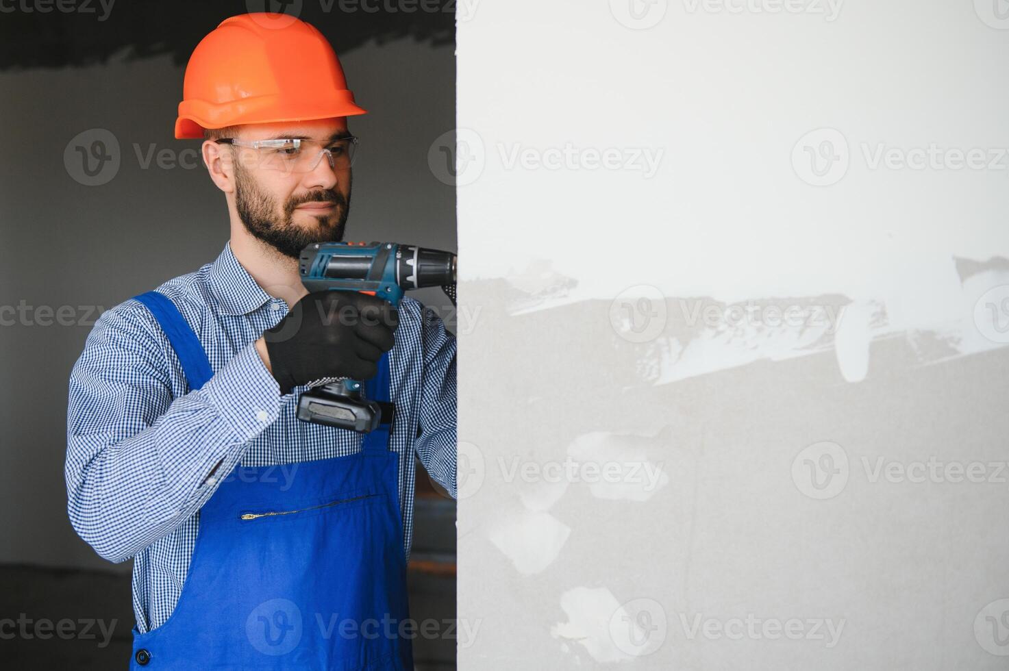 man drywall worker installing plasterboard sheet to wall photo