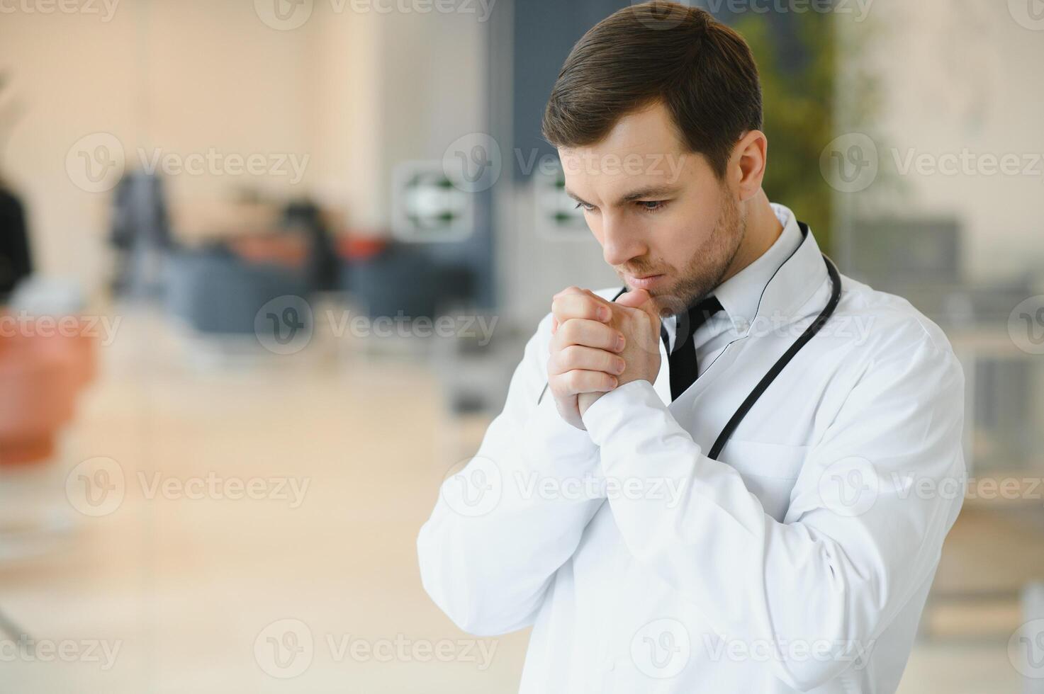 Praying for a successful operation. Cropped shot of a handsome male doctor praying. photo