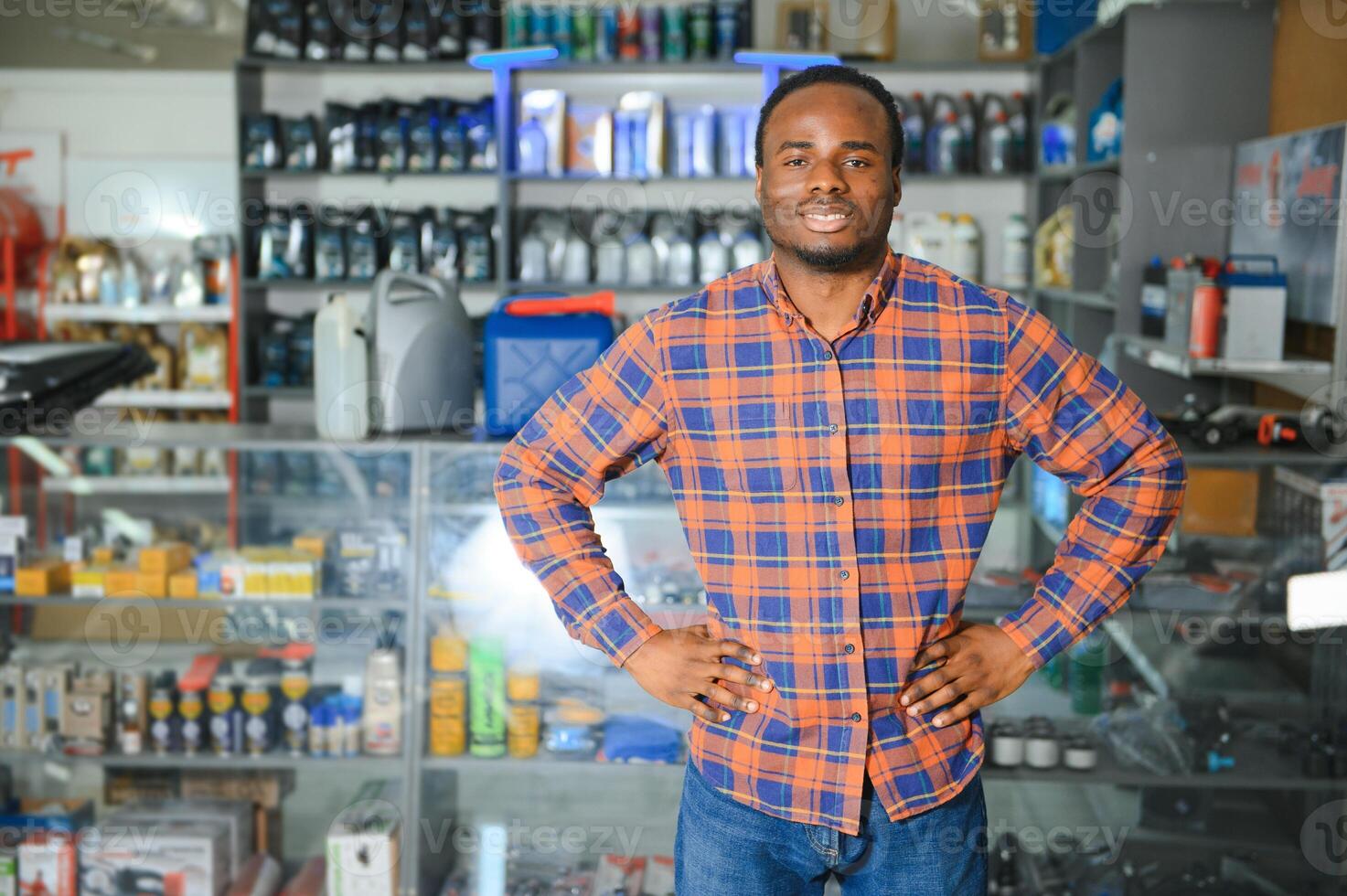 retrato de un hermoso africano vendedor en un auto partes almacenar. el concepto de coche reparar foto