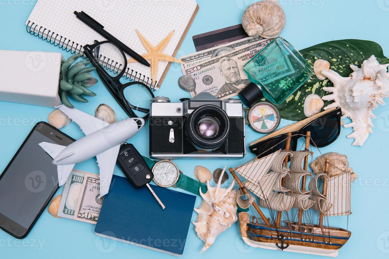 preparación para de viaje concepto, mirar, avión, dinero, pasaporte, lápices, libro, foto marco, lente en azul antecedentes con Copiar espacio.